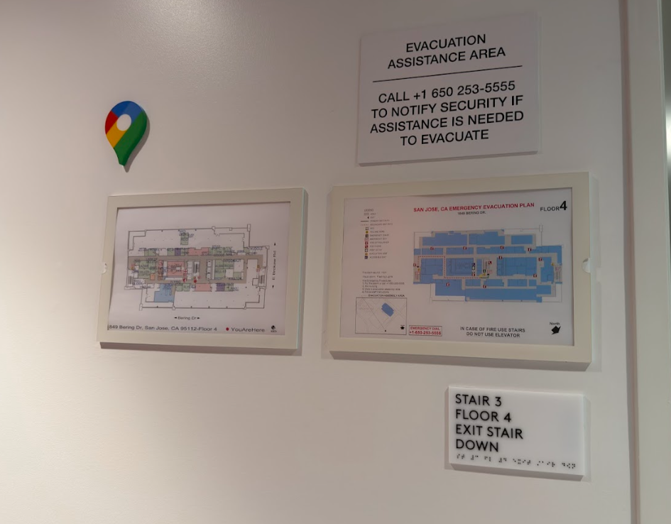 Evacuation assistance area signage with location marker and emergency floor plans for corporate workplace safety and wayfinding.