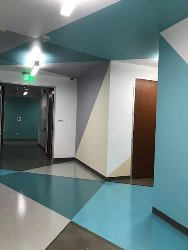 Custom geometric floor graphics defining pathways and zones in commercial building interior