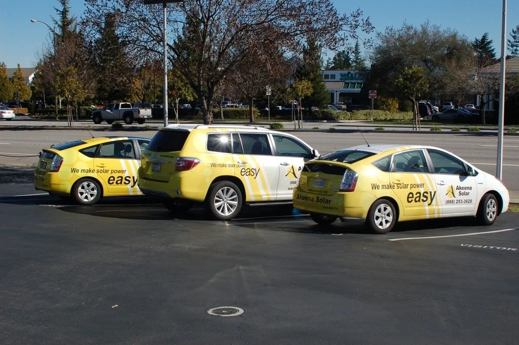 Matching fleet vehicle wraps with consistent branding across multiple company service cars.