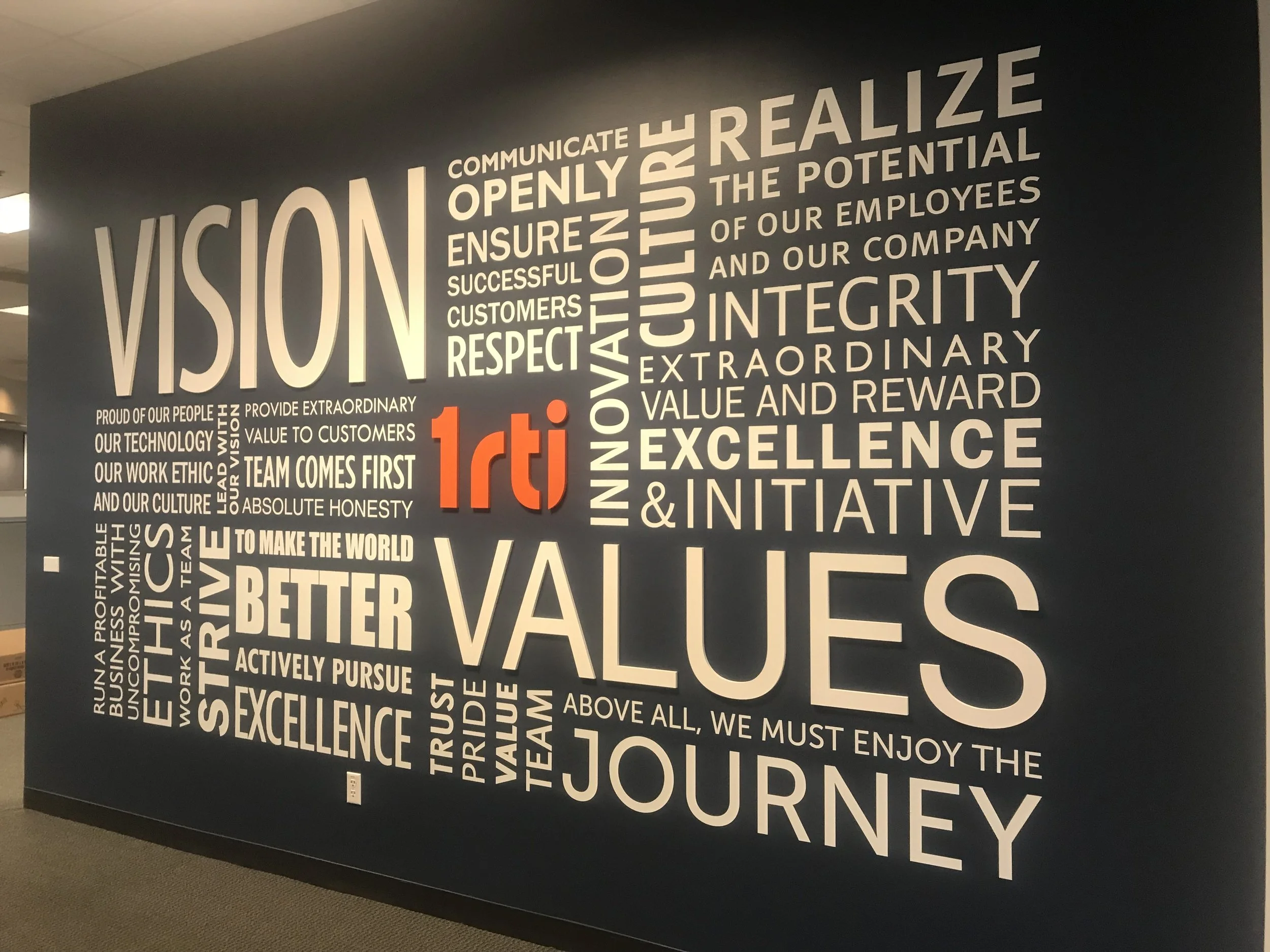 Dimensional environmental graphics for RTI showcasing company values and brand messaging in corporate interior