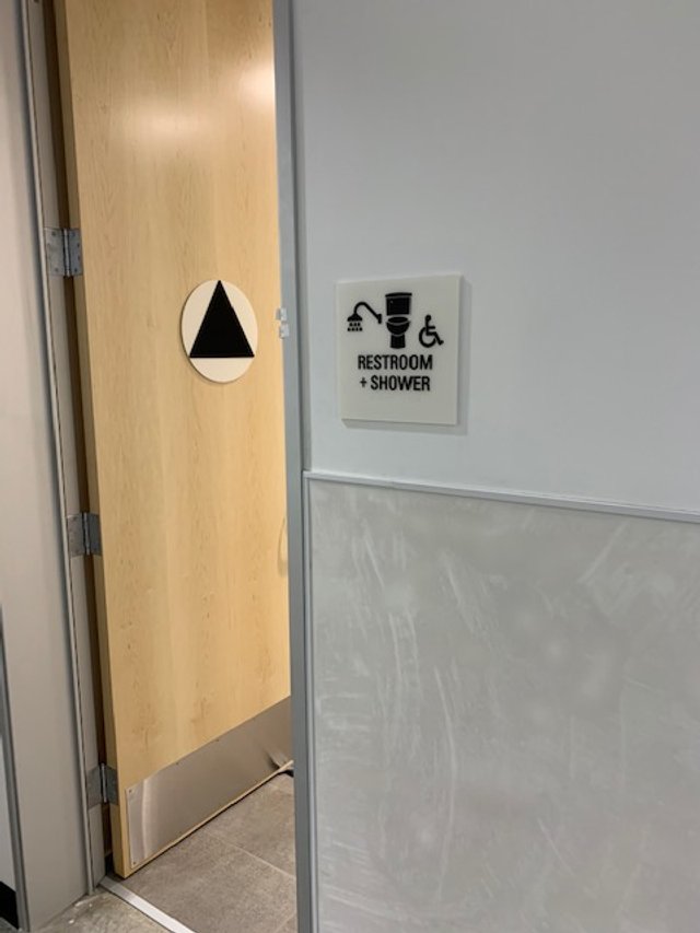 ADA-compliant accessible restroom signage with braille installed to support inclusive navigation in commercial facility