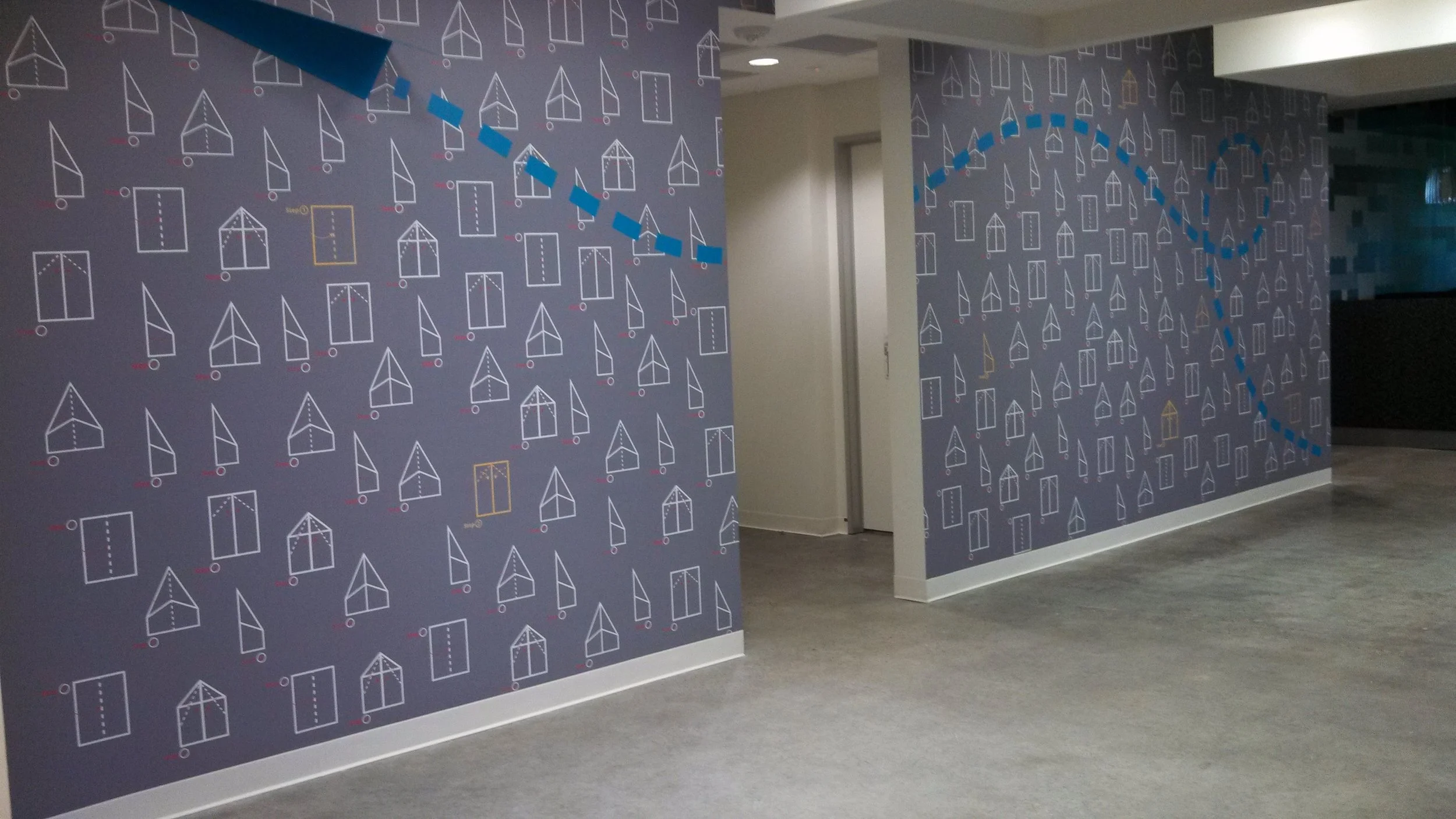Custom patterned environmental wallcovering installed in a commercial hallway to add visual interest and wayfinding support.