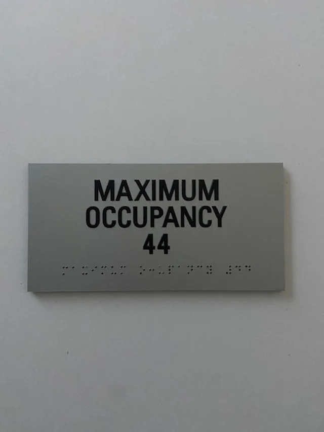 Code-compliant maximum occupancy plaque installed for safety and regulatory compliance in commercial space