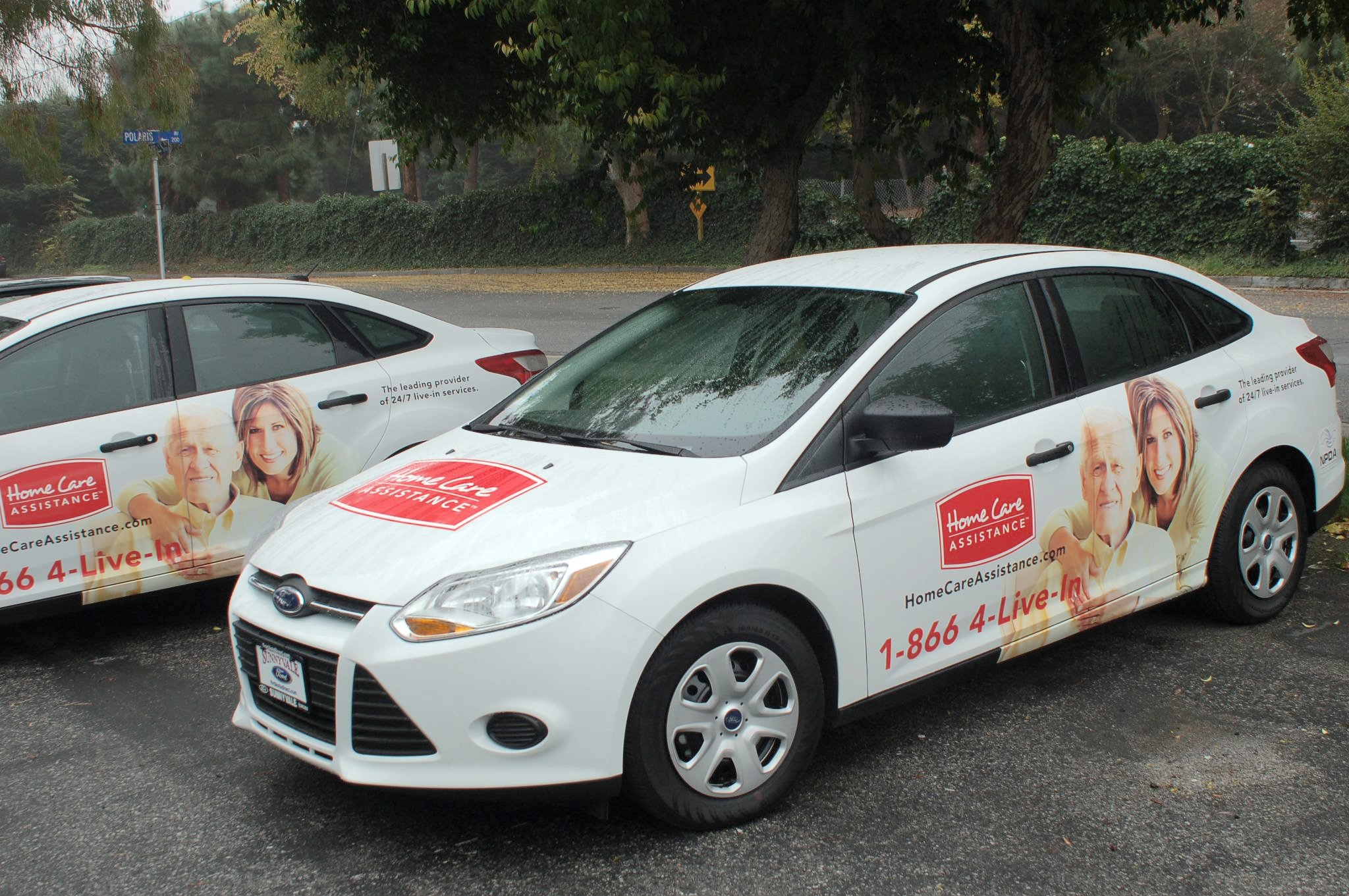Company car wrap with logo and contact information for local business marketing
