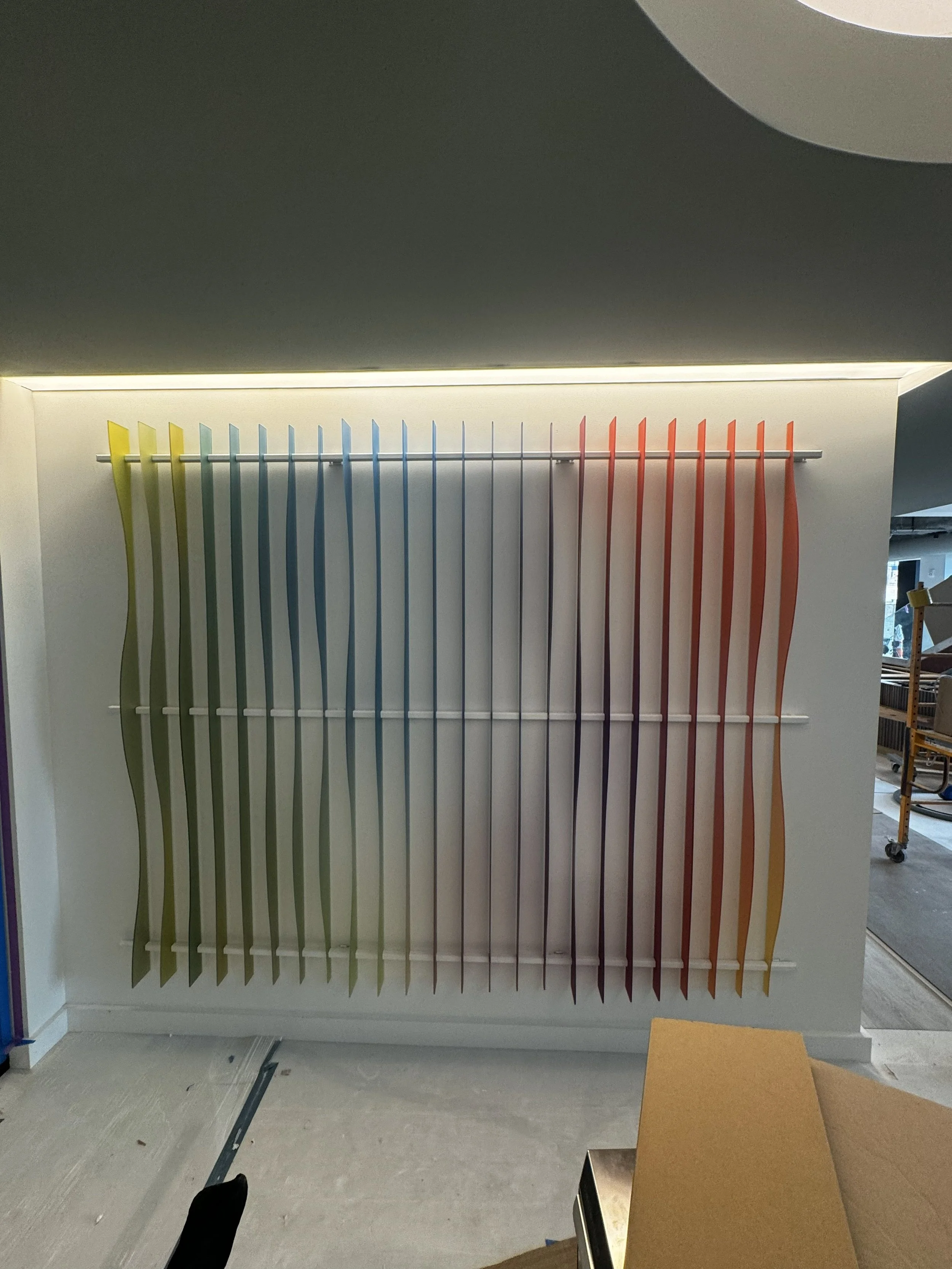 Installed custom acrylic 3D feature wall with multicolor vertical elements in the KPMG reception area in Minneapolis, Minnesota.