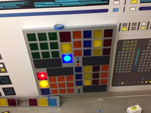 Close-up of custom fabricated interactive wall with lighting components and layered dimensional elements.