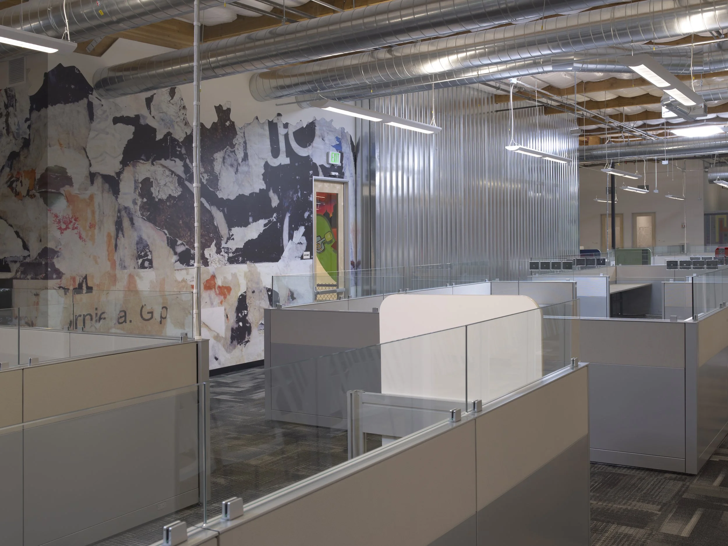 Custom environmental graphics integrated into a commercial office reception and collaboration space.