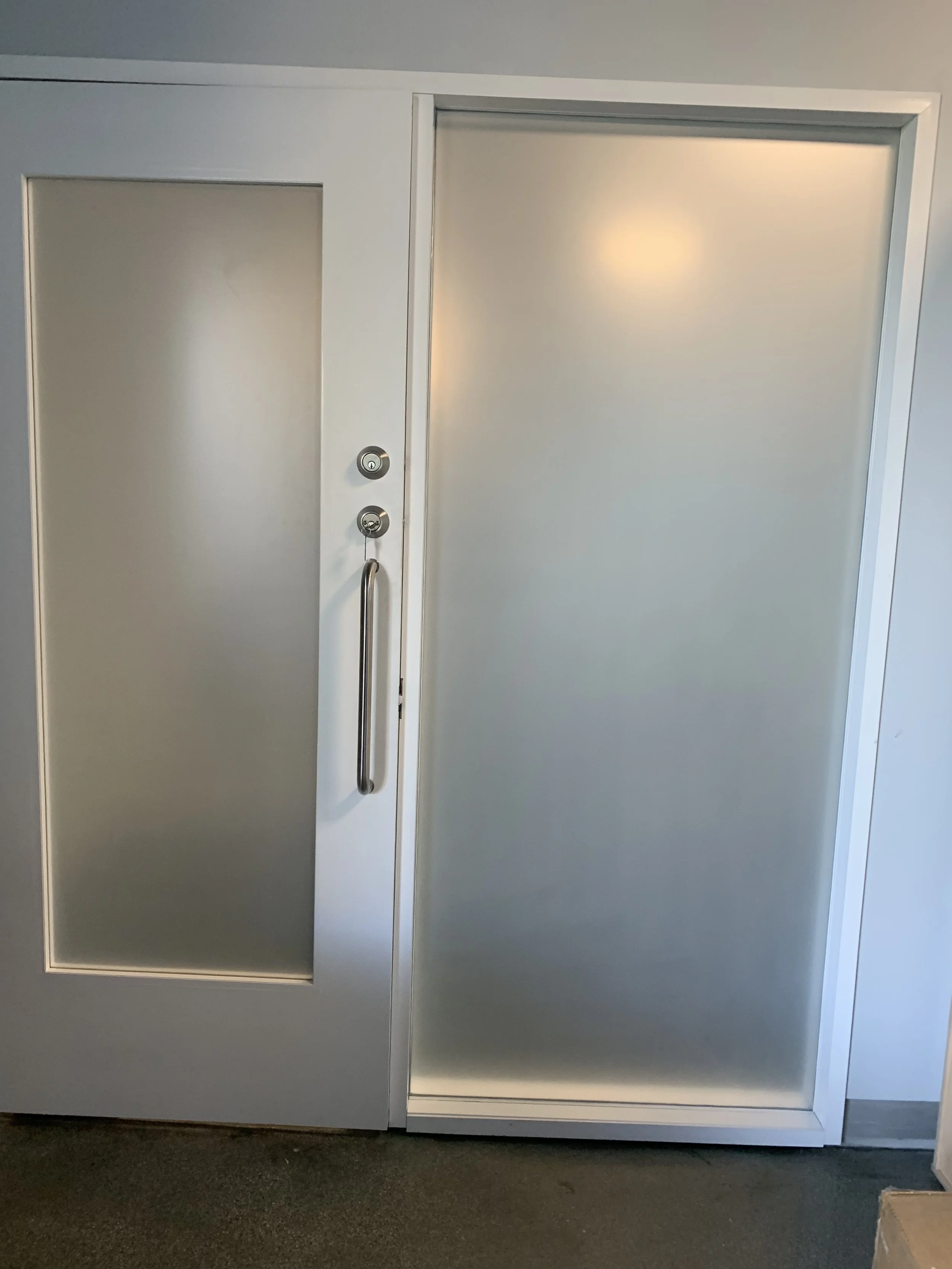 Frosted privacy window film on glass office door providing visual privacy and light diffusion