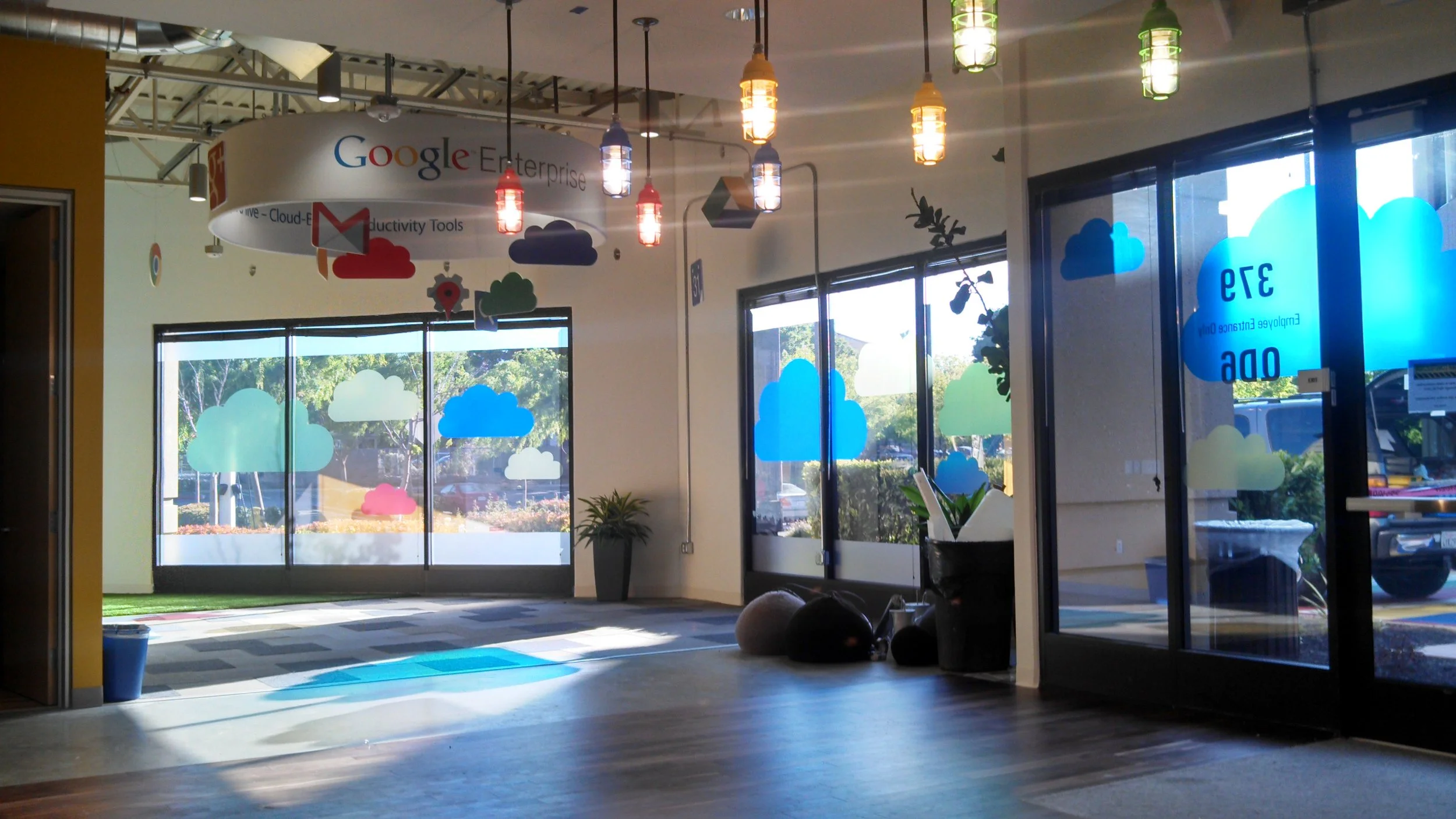 Custom decorative window film with cloud graphics applied to glass walls for branded office design and privacy.