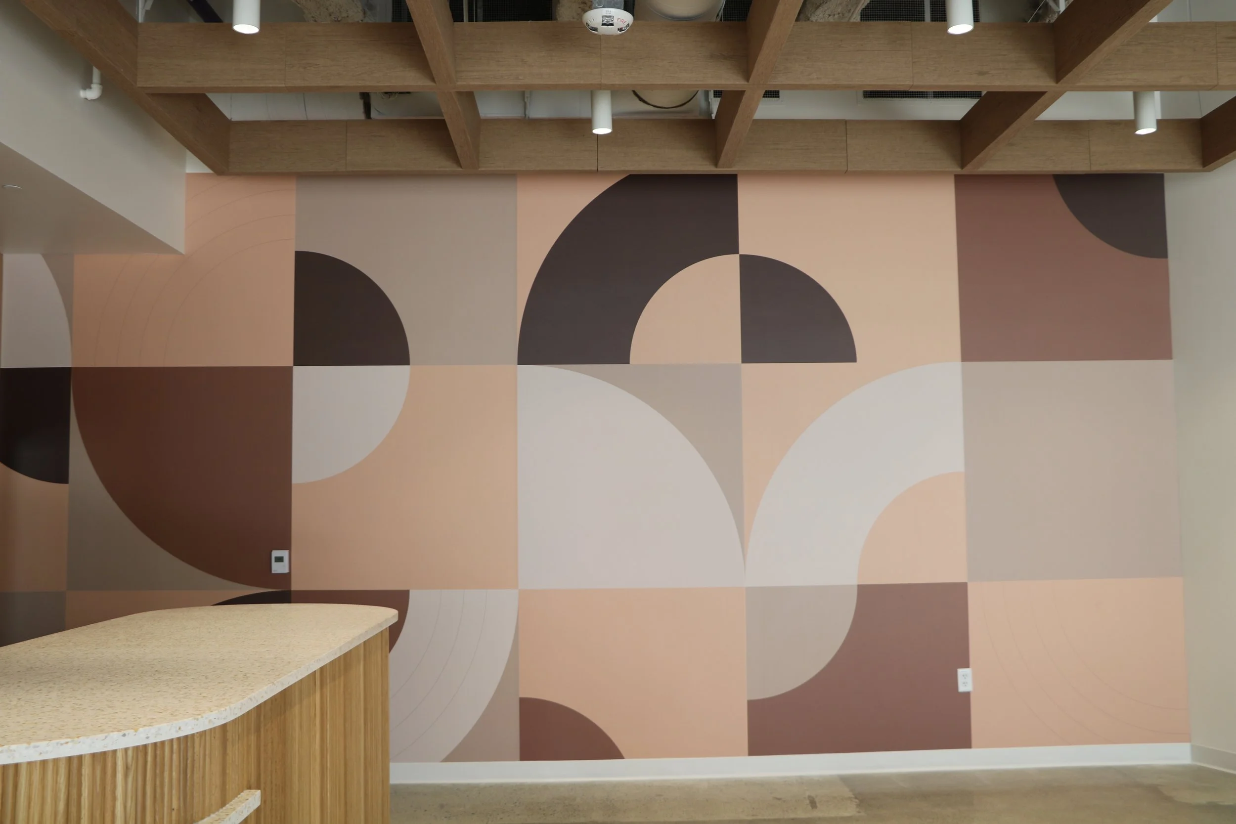 Wide view of commercial breakroom kitchen featuring custom wallcovering for modern workplace design.