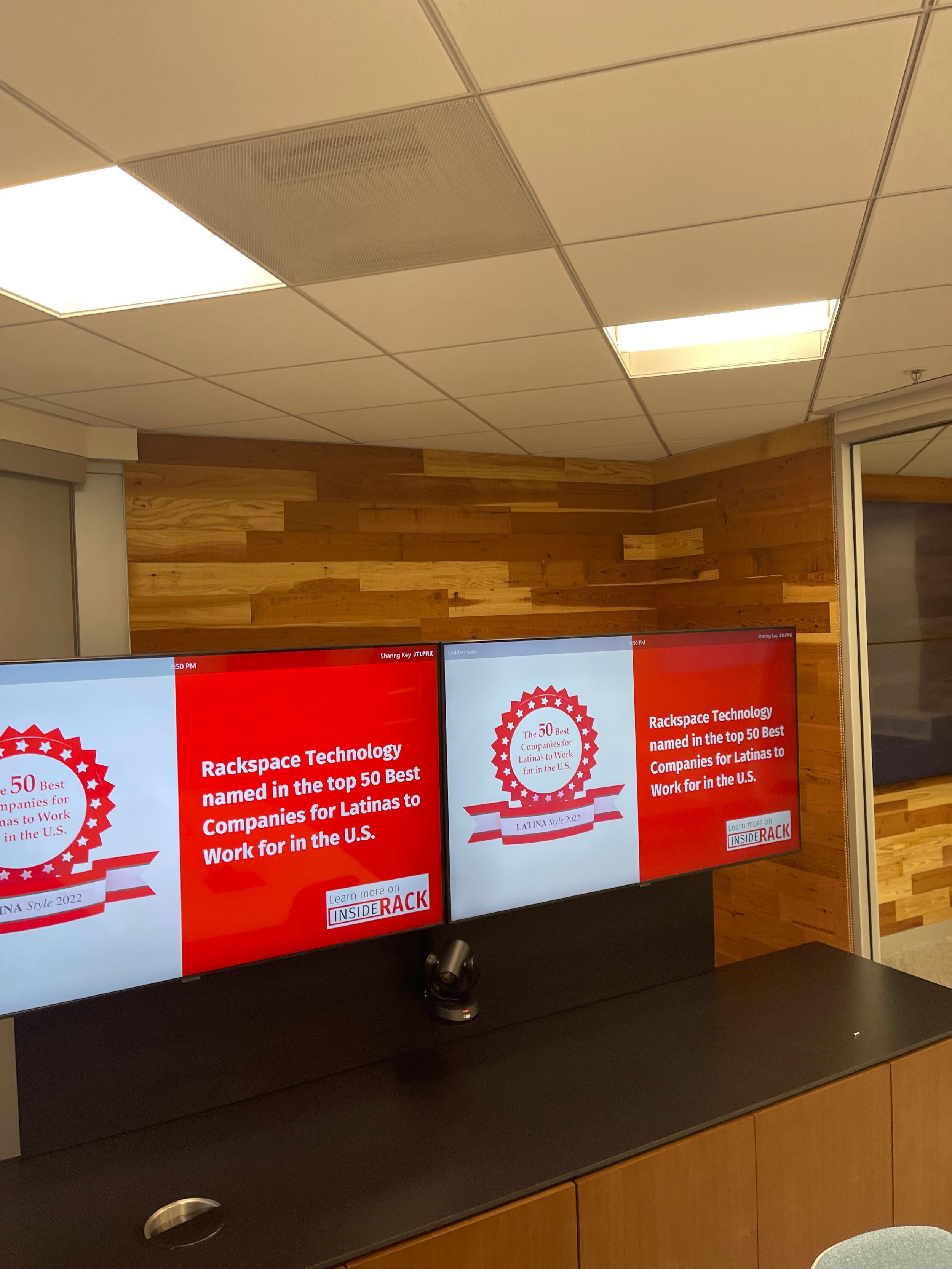 Custom architectural wood wall panels behind televisions in commercial office lobby