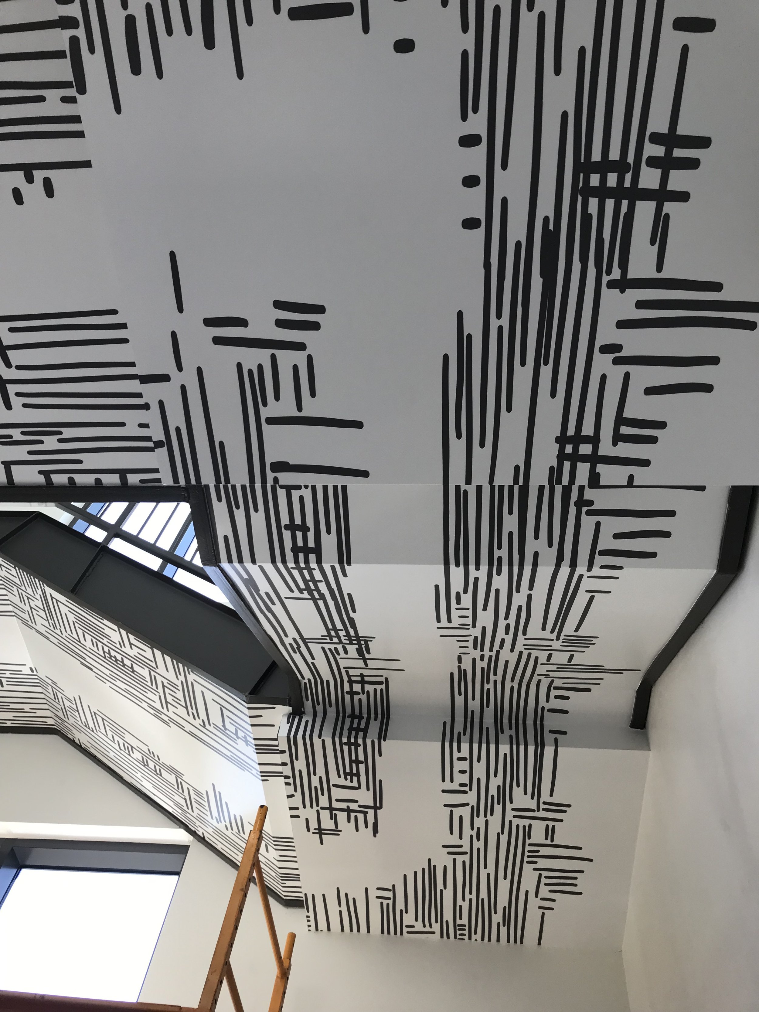 Multi-level view of finished stair wallcovering installation at Google Santa Cruz, showcasing full-height environmental graphics integrated into the architectural space.