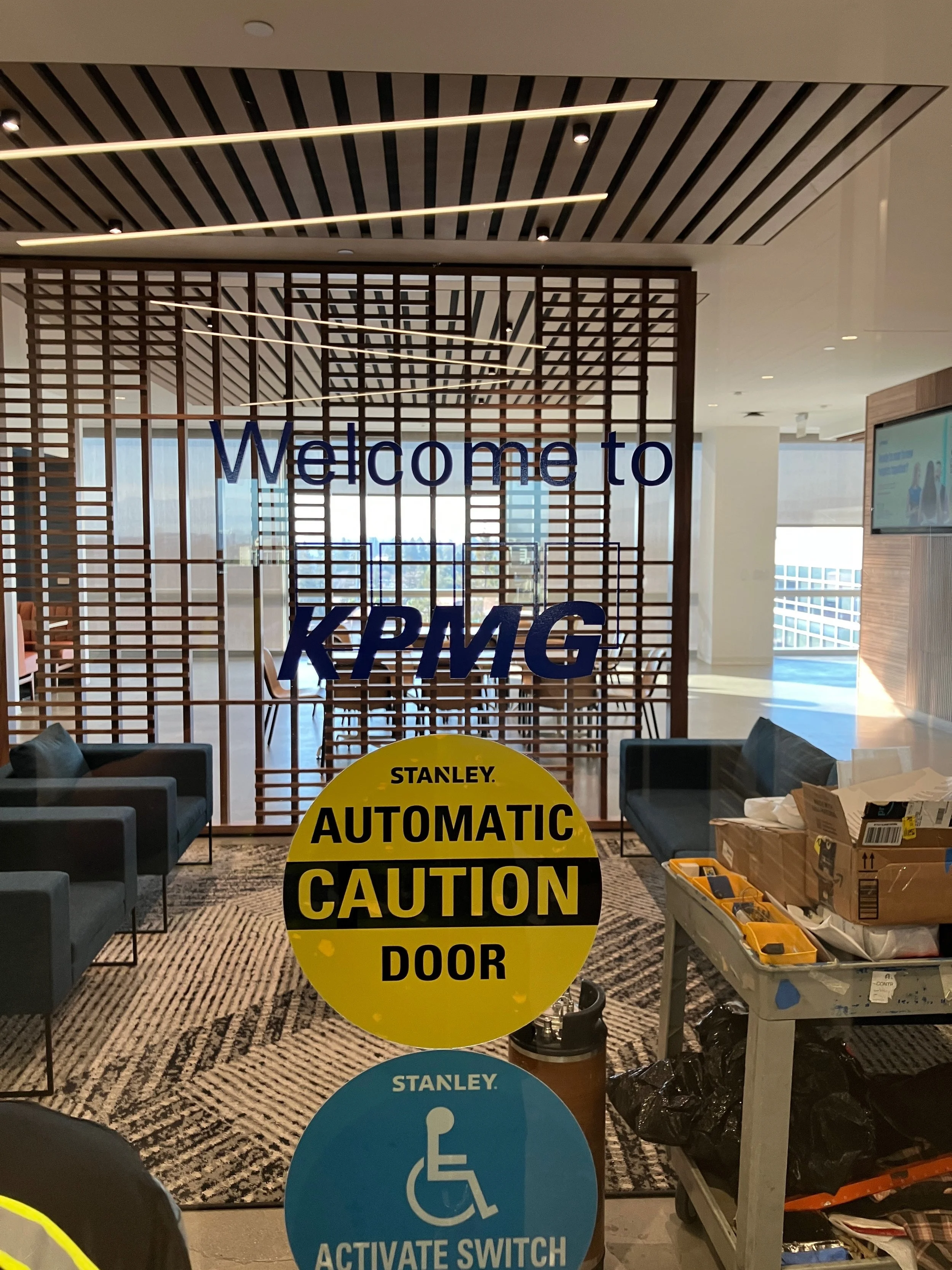 Welcome to KPMG vinyl graphics installed on glass entry wall for branded reception experience at the KPMG San Jose office.