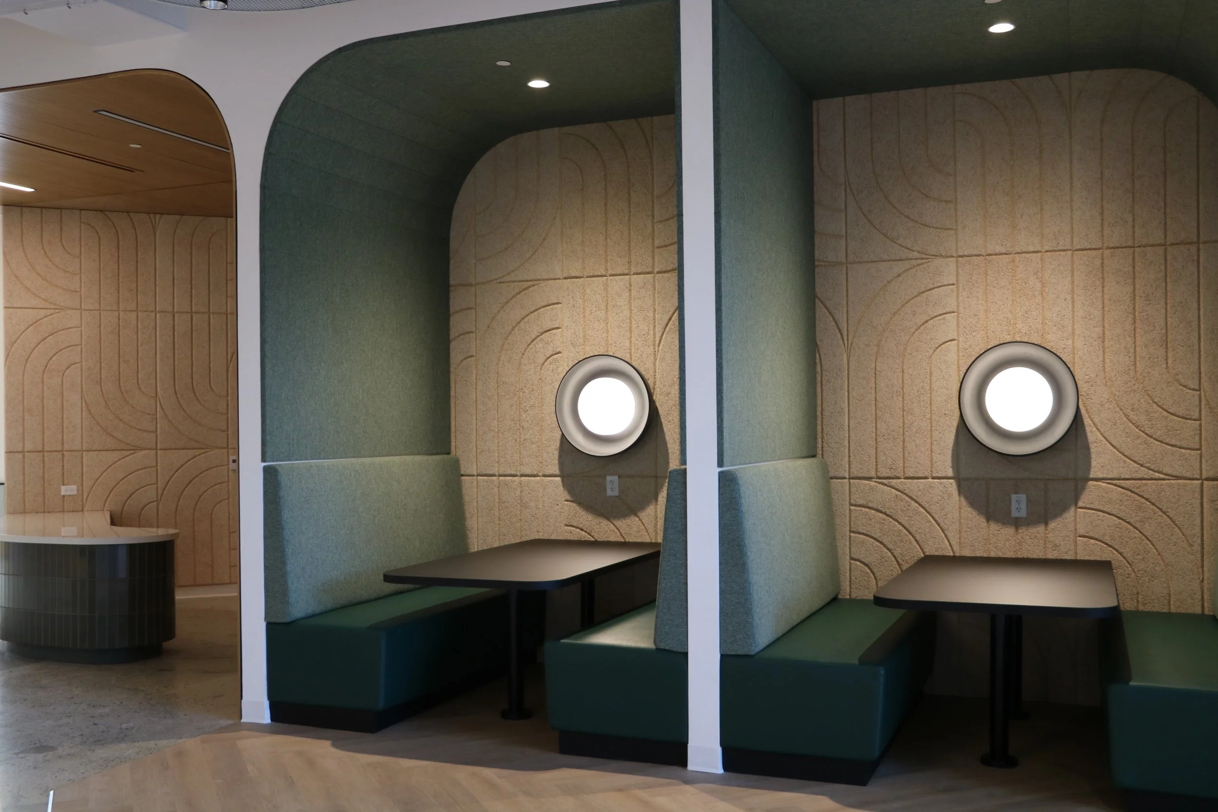 BAUX Wood Wool Curve acoustic wall panels installed in commercial office booth seating area for sound control and modern interior design.