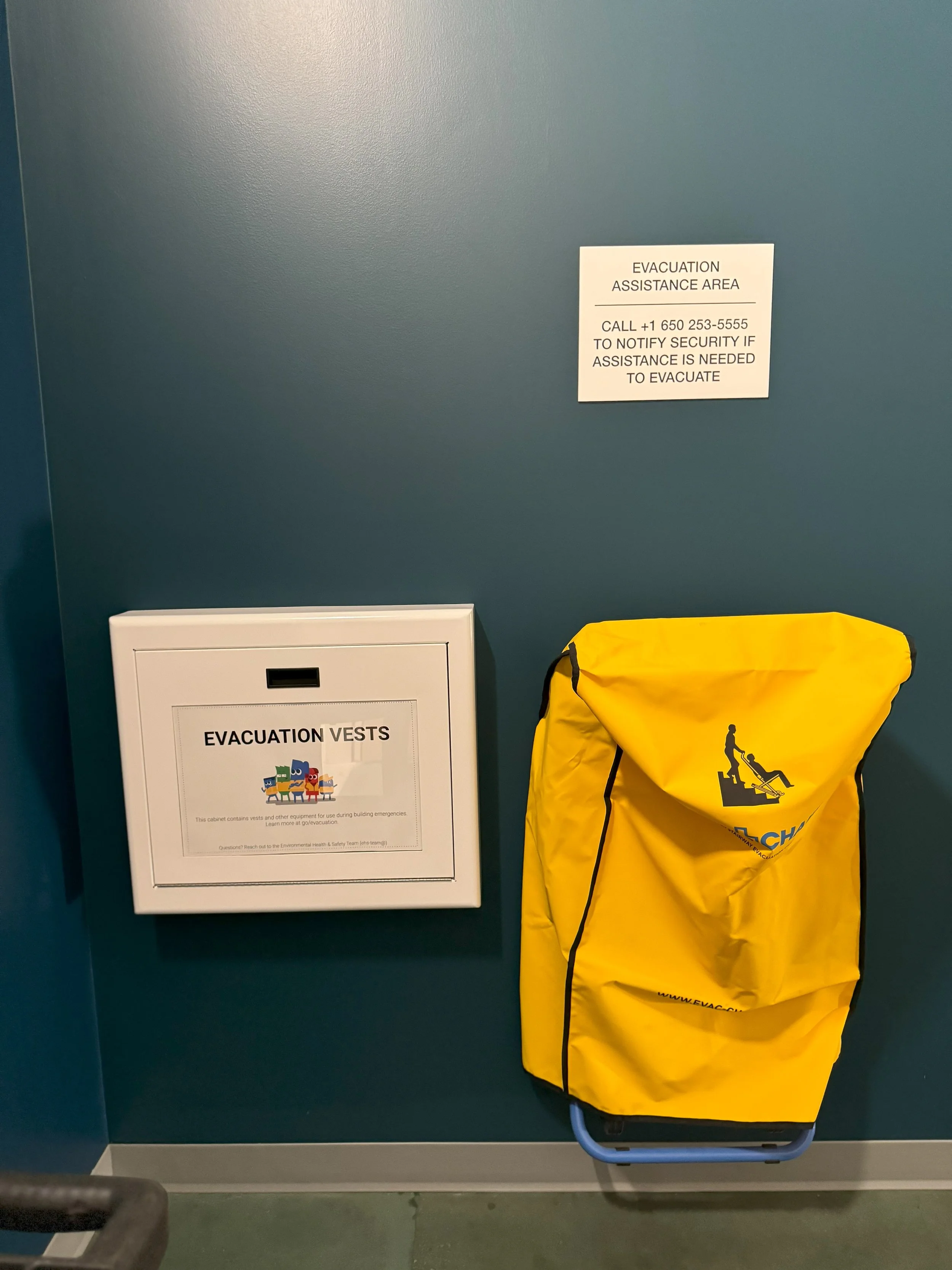 Safety and emergency signage area with wall-mounted instructions and equipment for workplace preparedness.