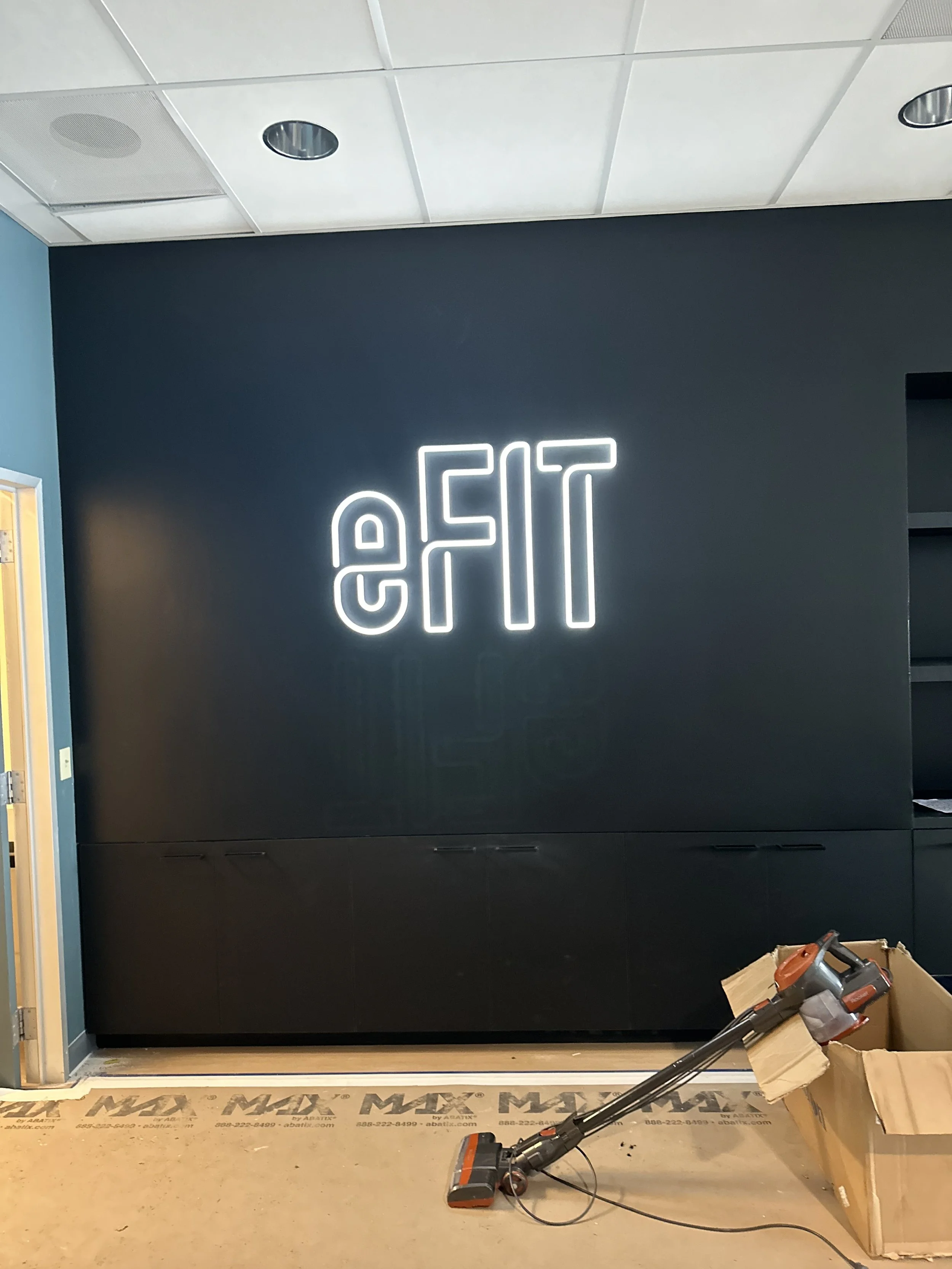 Illuminated signage installed to add branding to a tech  company gym