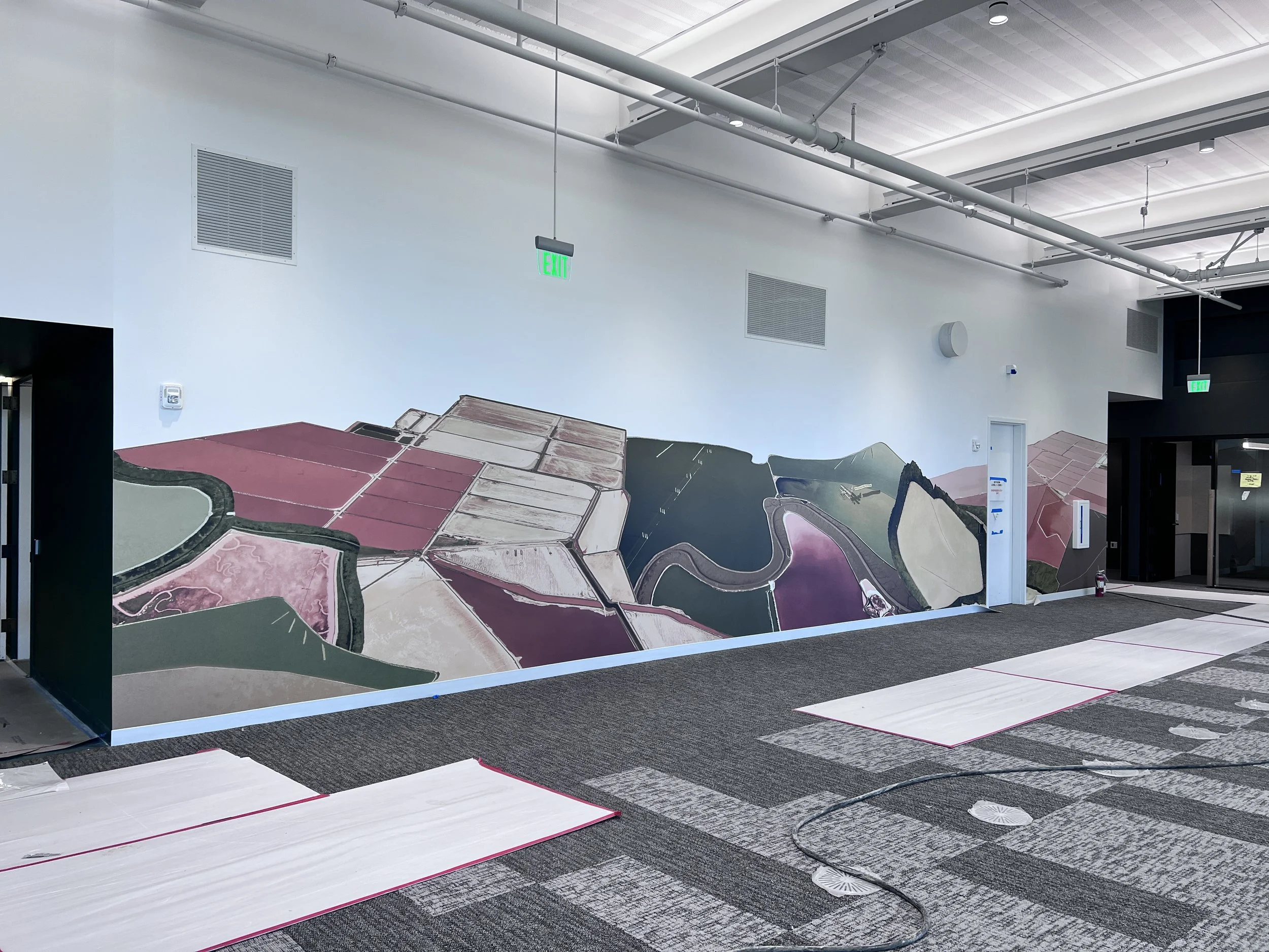 ustom illustrated landscape wallcovering creating a playful feature wall in a collaborative office space.