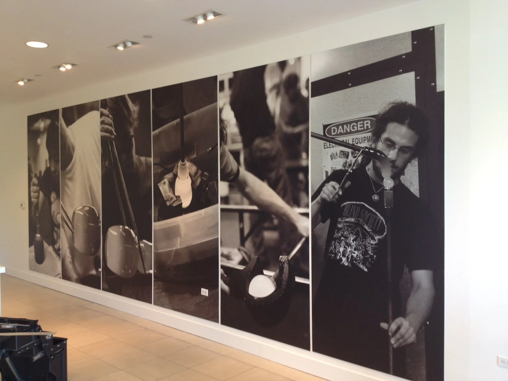 Large-format black-and-white photography wall mural installed as a storytelling feature wall in a workplace.