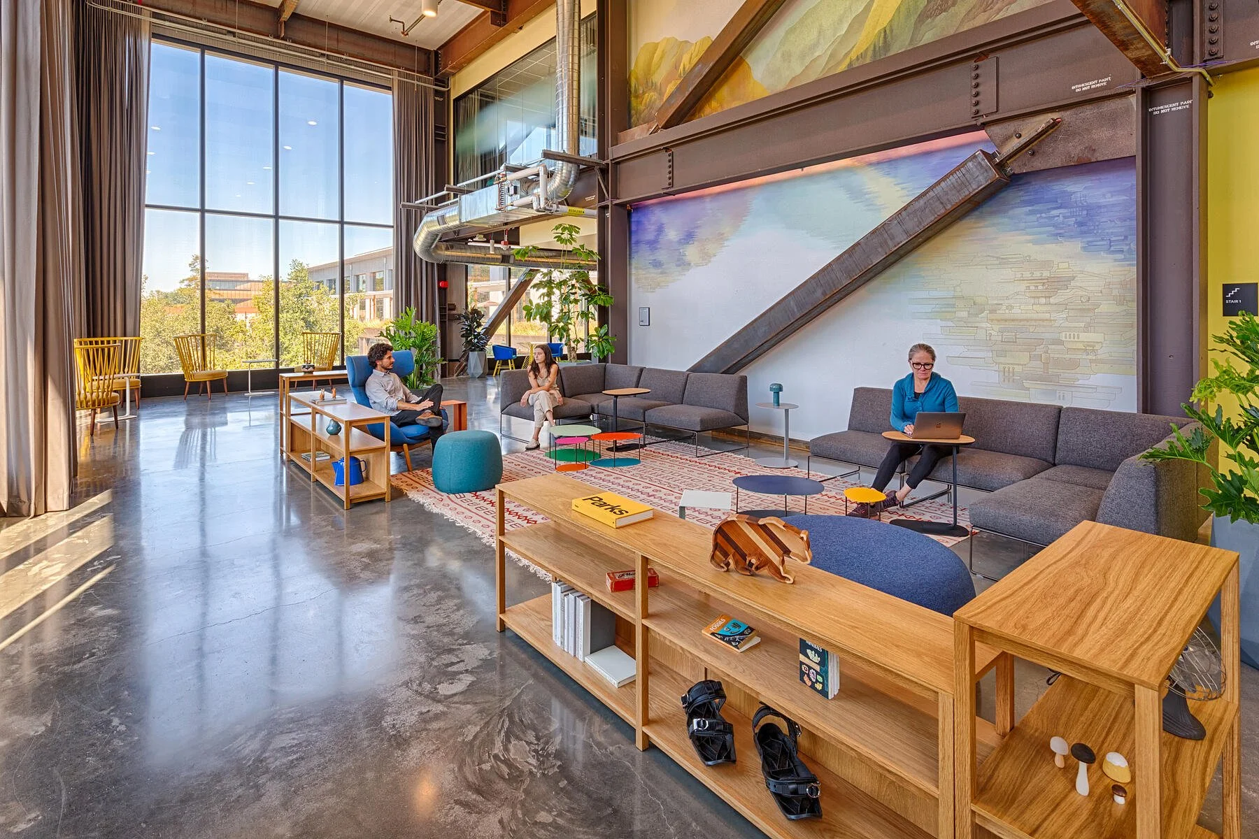 Modern office lounge featuring large-scale landscape wall mural and custom environmental graphics in an open commercial workspace setting