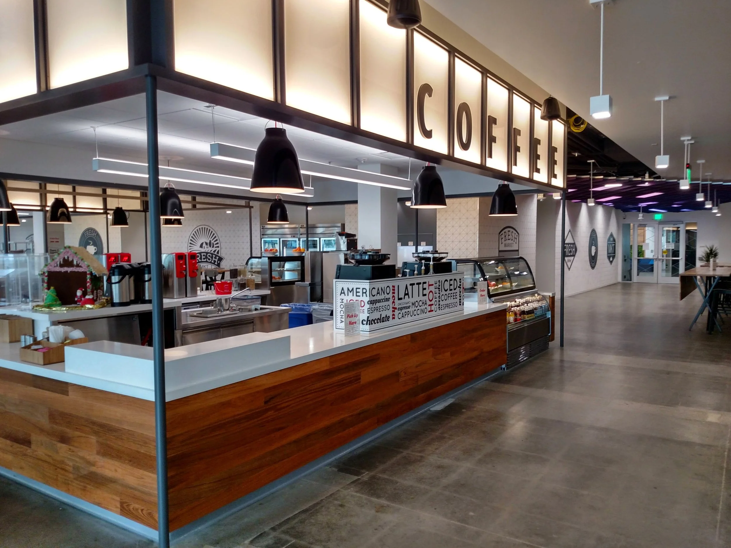 Corporate office café and breakroom environment featuring custom commercial wallcoverings, branded graphics, and environmental signage as part of a workplace refresh by JP Digital.