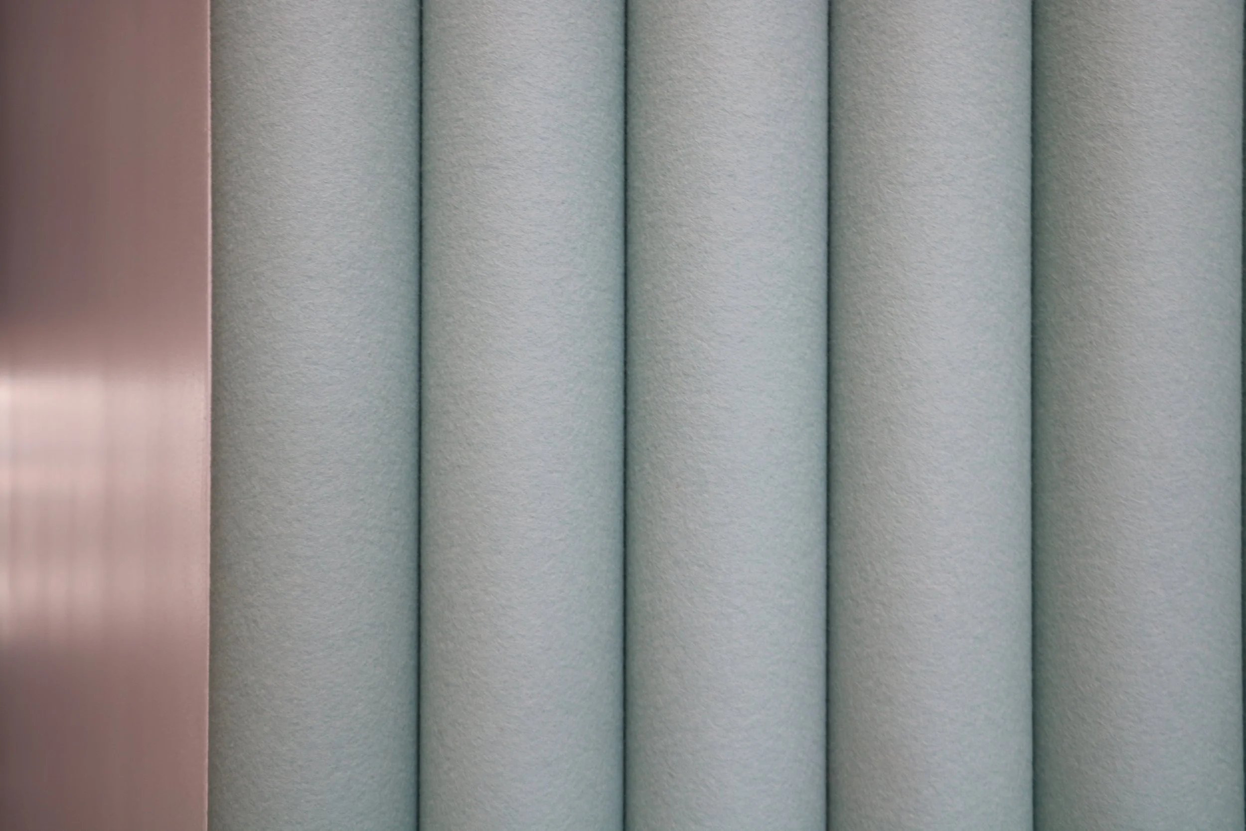 Close-up of FilzFelt ARO Plank acoustic wall with vertical PET felt slats for noise reduction in modern office environments.