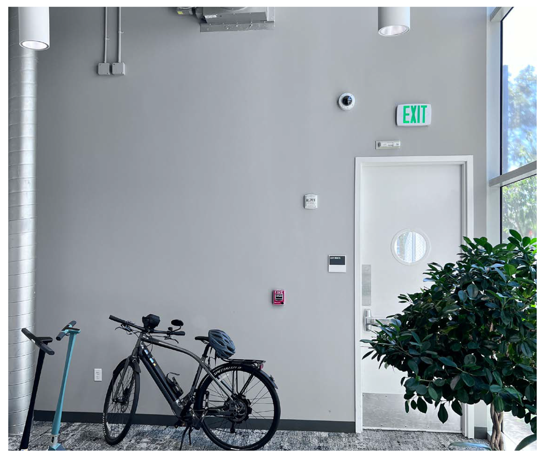 Blank gray exit wall and door area prior to environmental graphics installation in the Amphitheatre hallway.