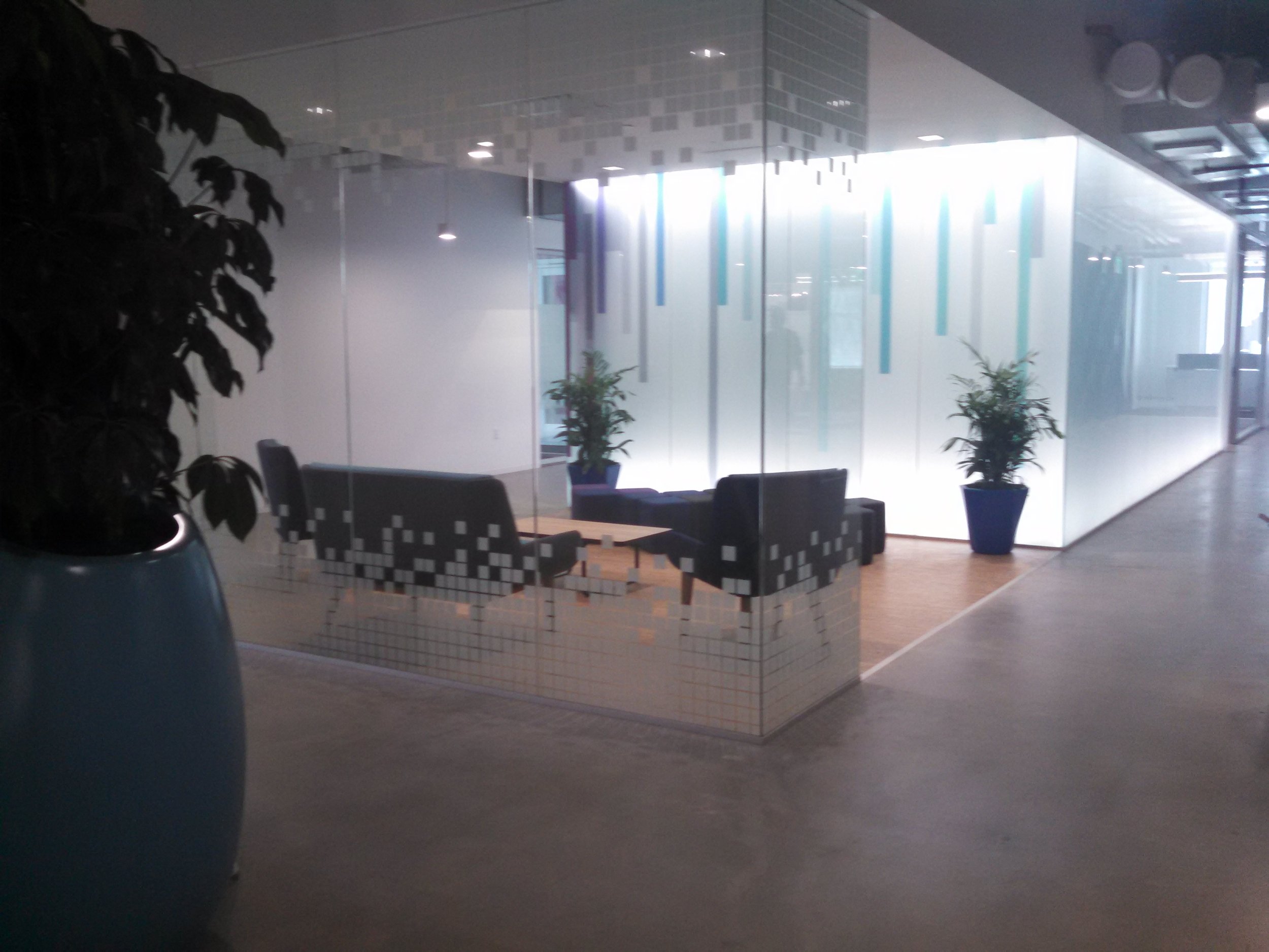 Tile privacy window film installed on conference room glass panels in a contemporary corporate office.