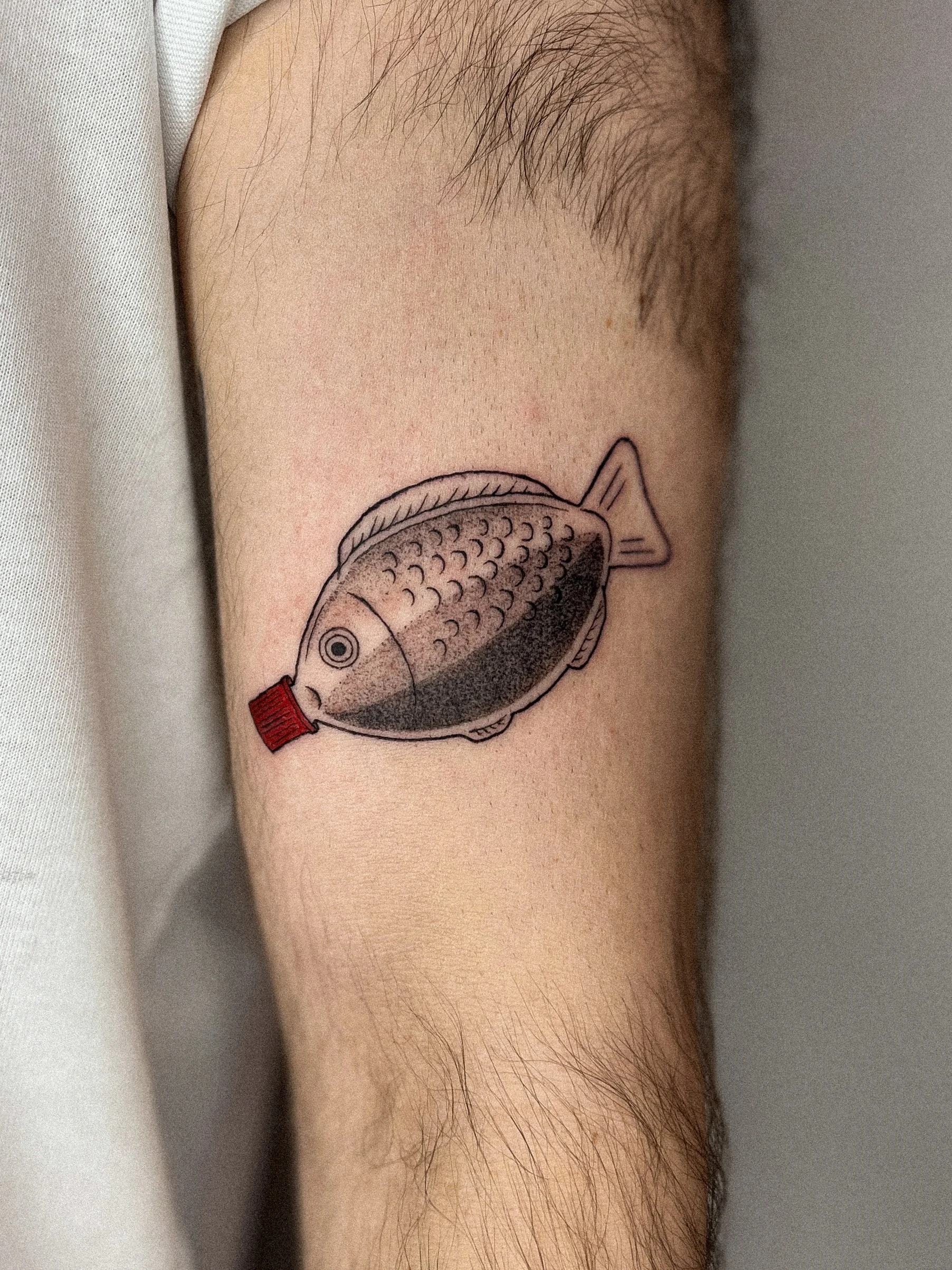 Haifisch-Tattoo auf dem Oberarm einer Person.