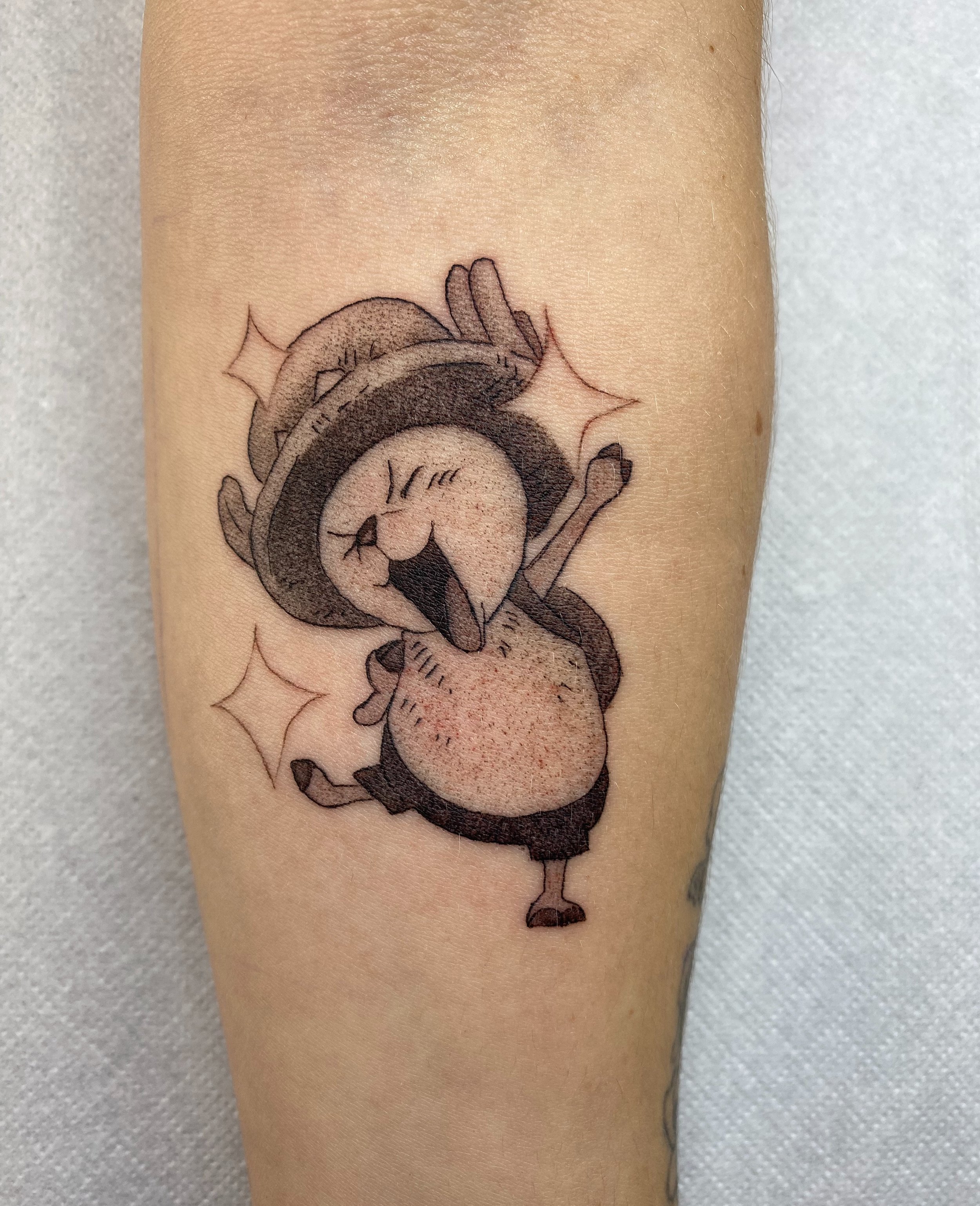 Tattoo eines lachenden Pandabären mit einem Hut, der vor Freude jubelt.