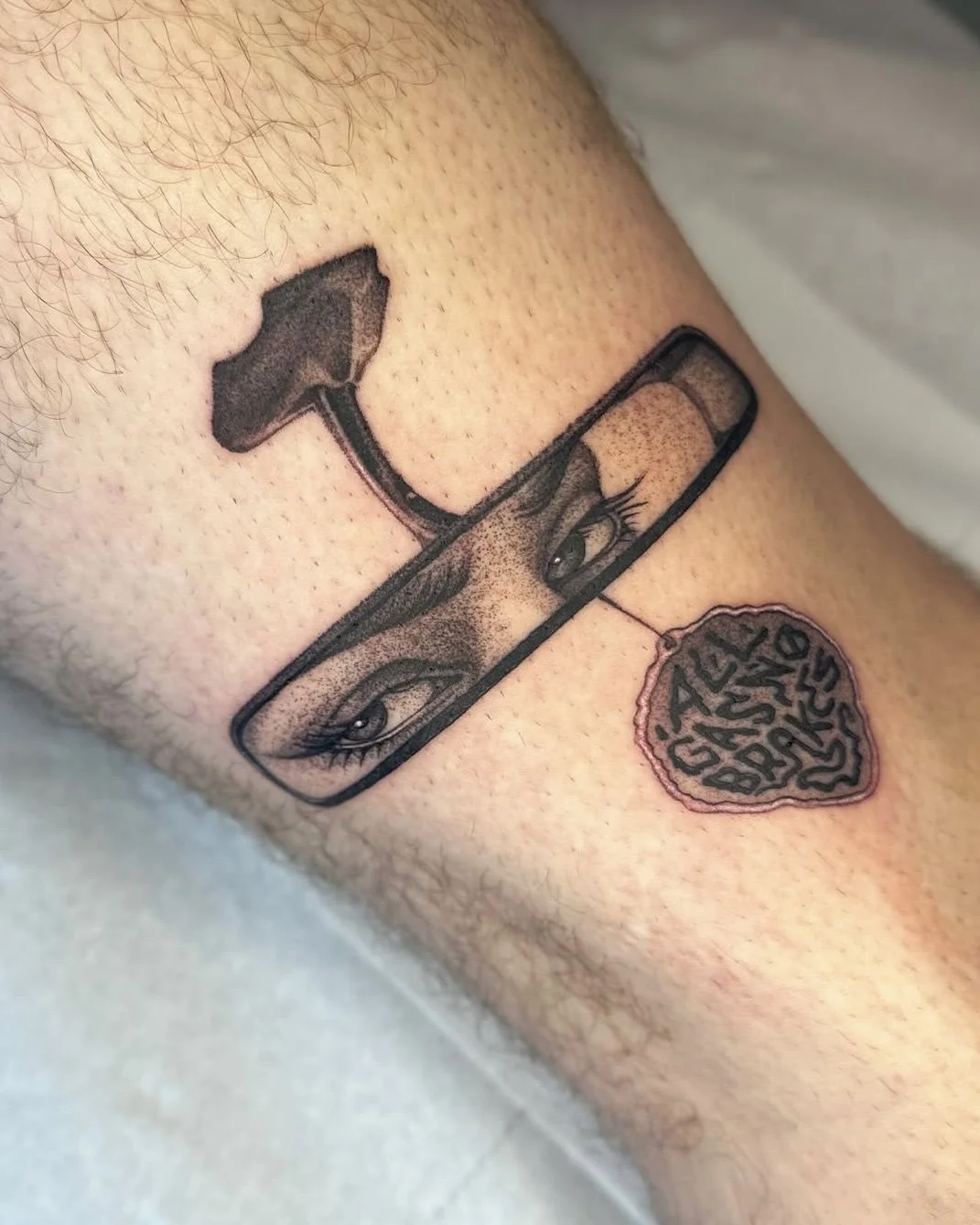 Tattoo eines Frauenauges, das in einer Brille steckt, mit einem Pilz und einem Herz mit der Aufschrift »GIRL BOSS« darunter.