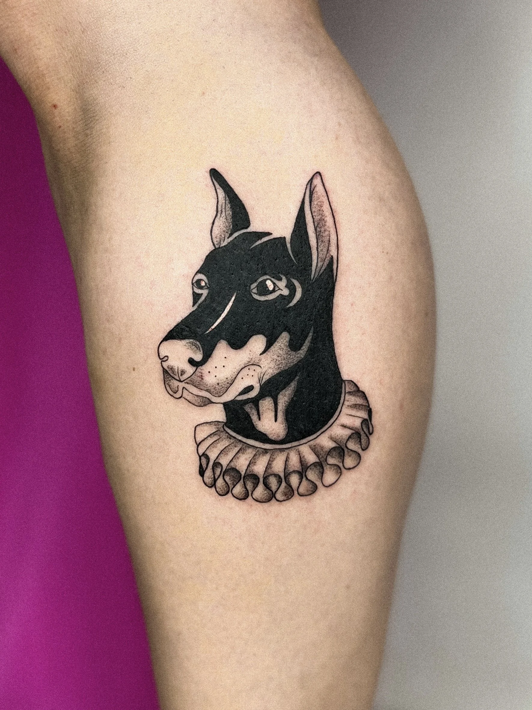 Tattoo eines Hundes mit römischem Halskragen
