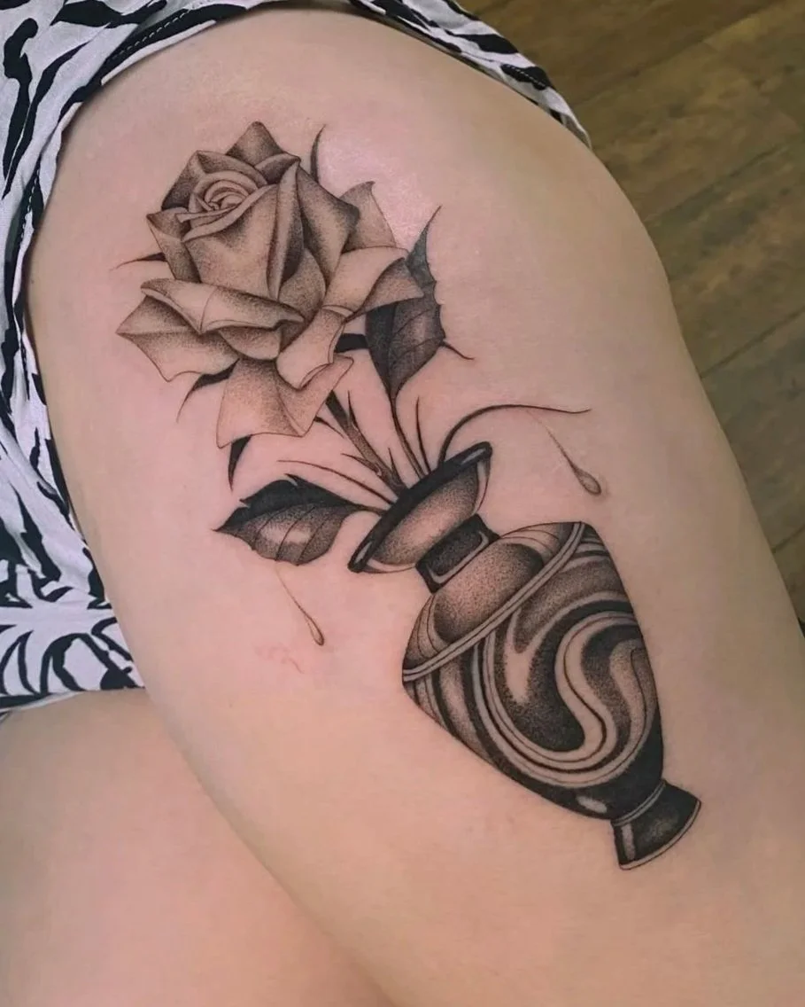 Tattoo einer Rose in einer Vase auf dem Oberarm, in Schwarzweiß, mit schattiertem Stil.