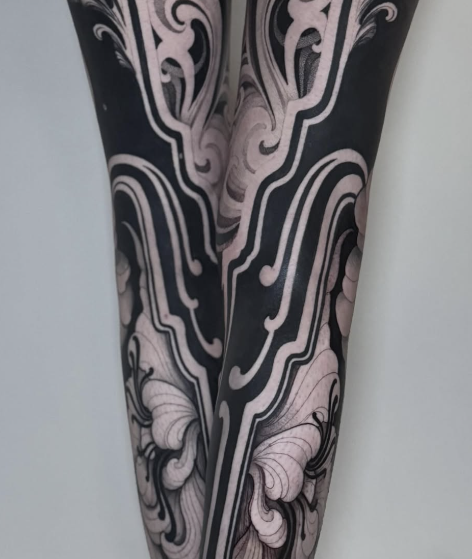 Nahaufnahme eines Arm Tattoos mit schwarzen und weißen geschwungenen, Linien und Mustern.