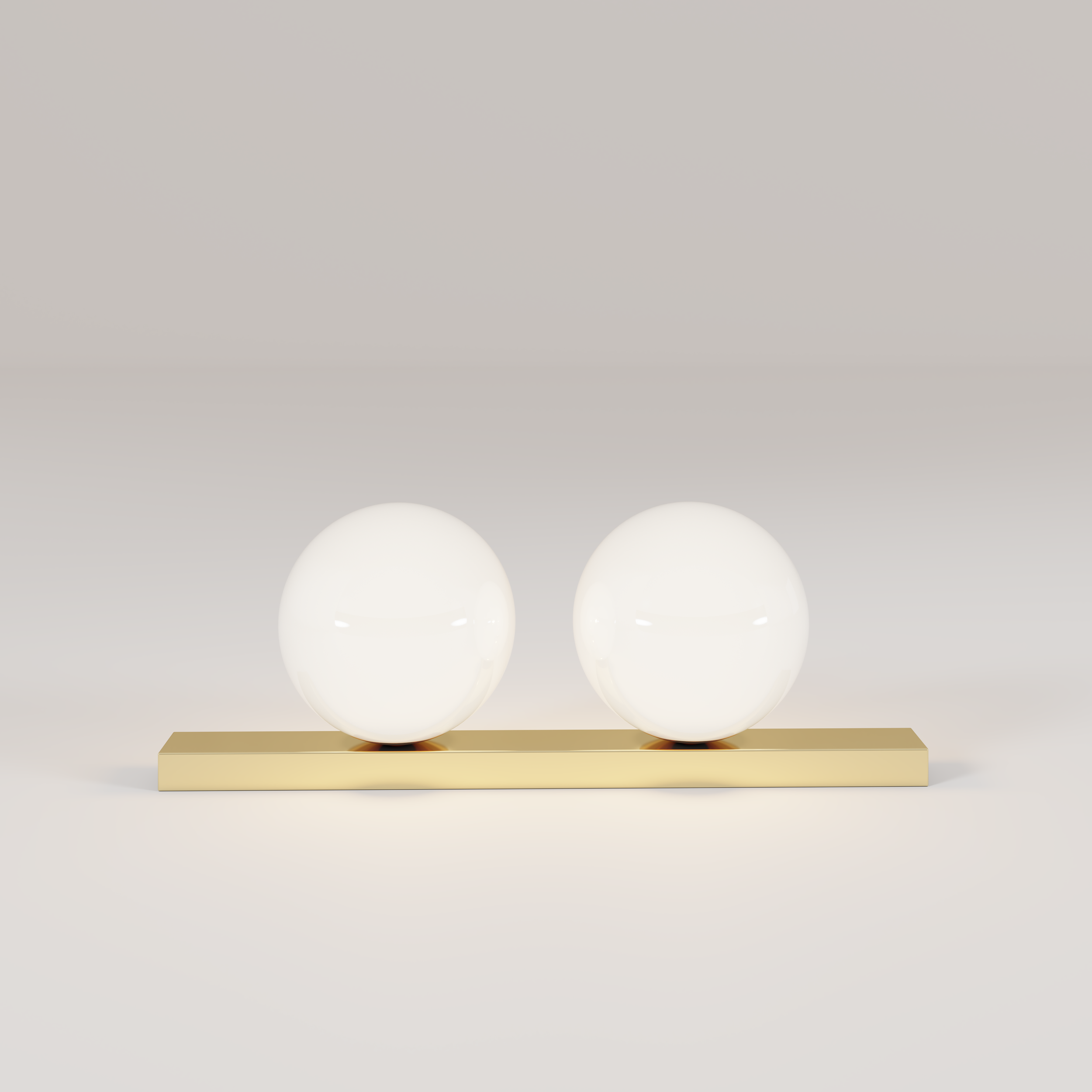 Decorative lamp with two spherical white glass bulbs on a rectangular gold base against a plain light background.