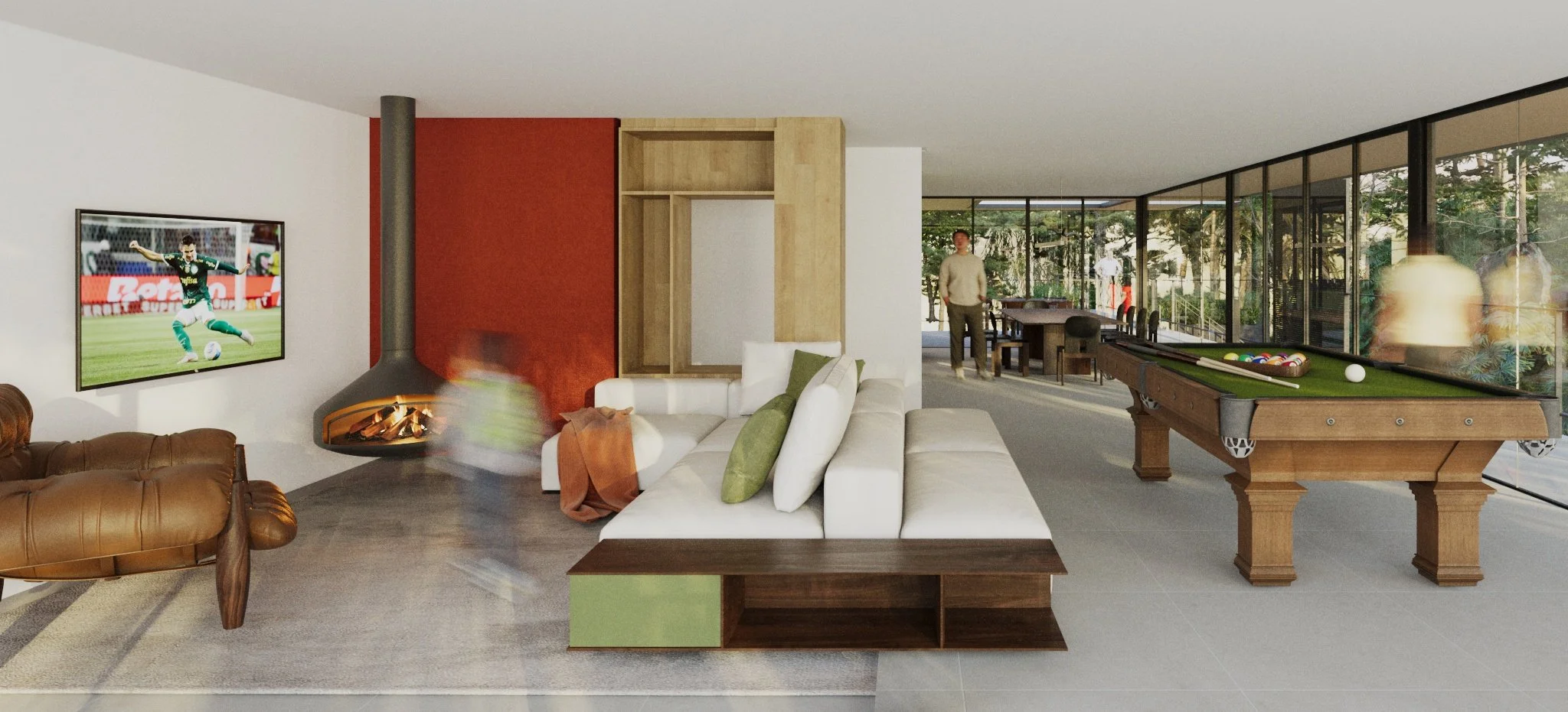 Modern living room with a wall-mounted TV showing a soccer game, a hanging fireplace, a white sectional sofa with green pillows, a brown leather armchair, a pool table, and large glass windows with a view of a lush outdoor area.