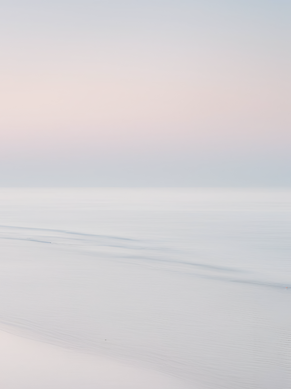 Smooth, pastel-colored seascape with gentle waves and a soft sky, creating a serene and minimalist scene.