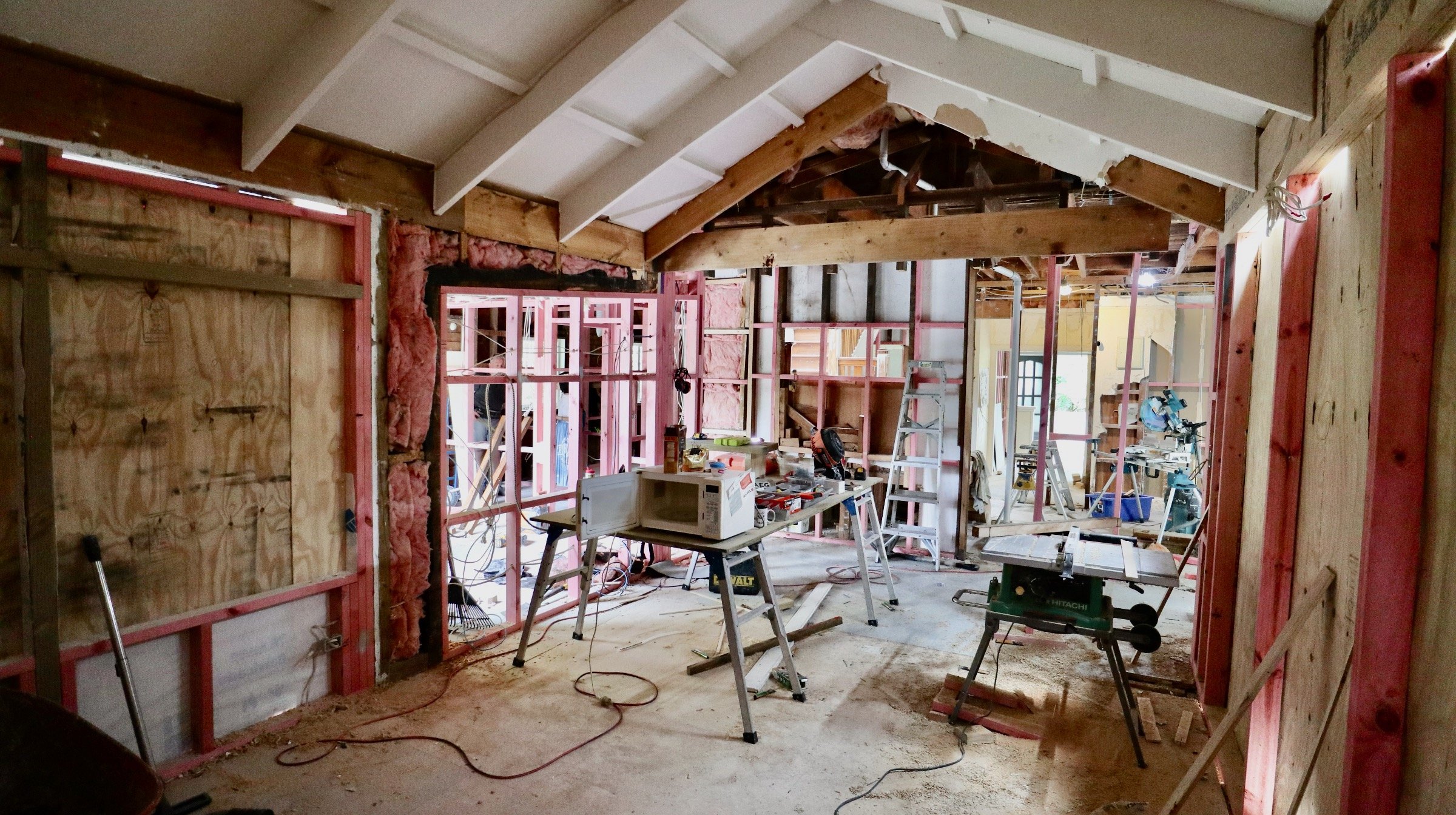 Room under renovation with building materials, tools, and construction work ongoing.