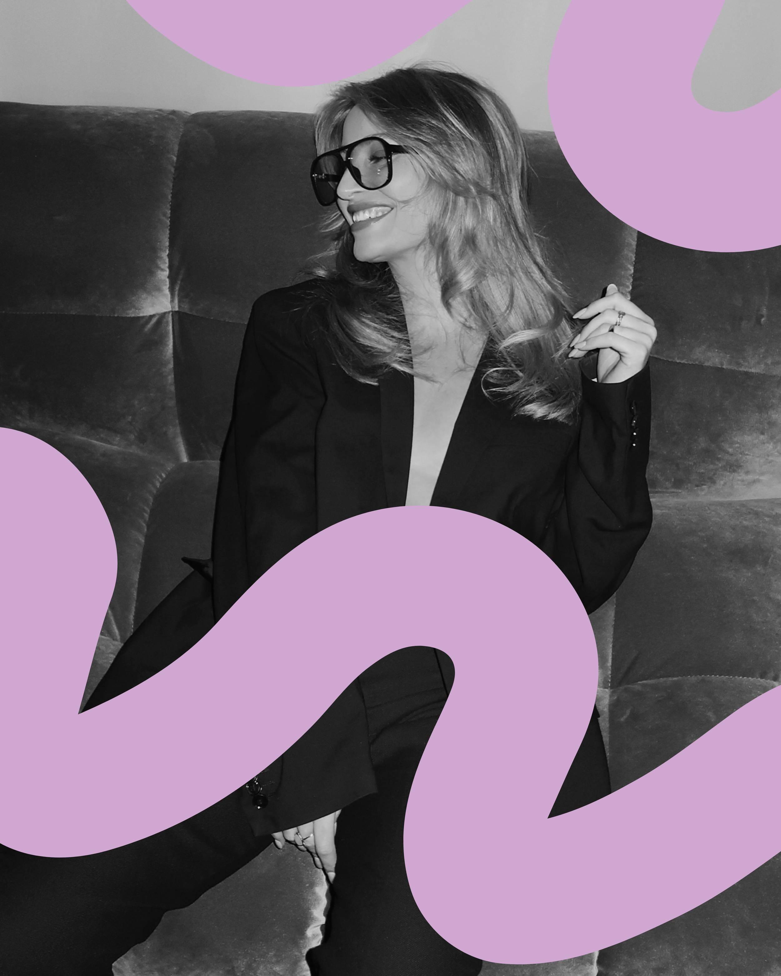 Person sitting on a sofa wearing glasses, relaxed portrait in a creative studio environment