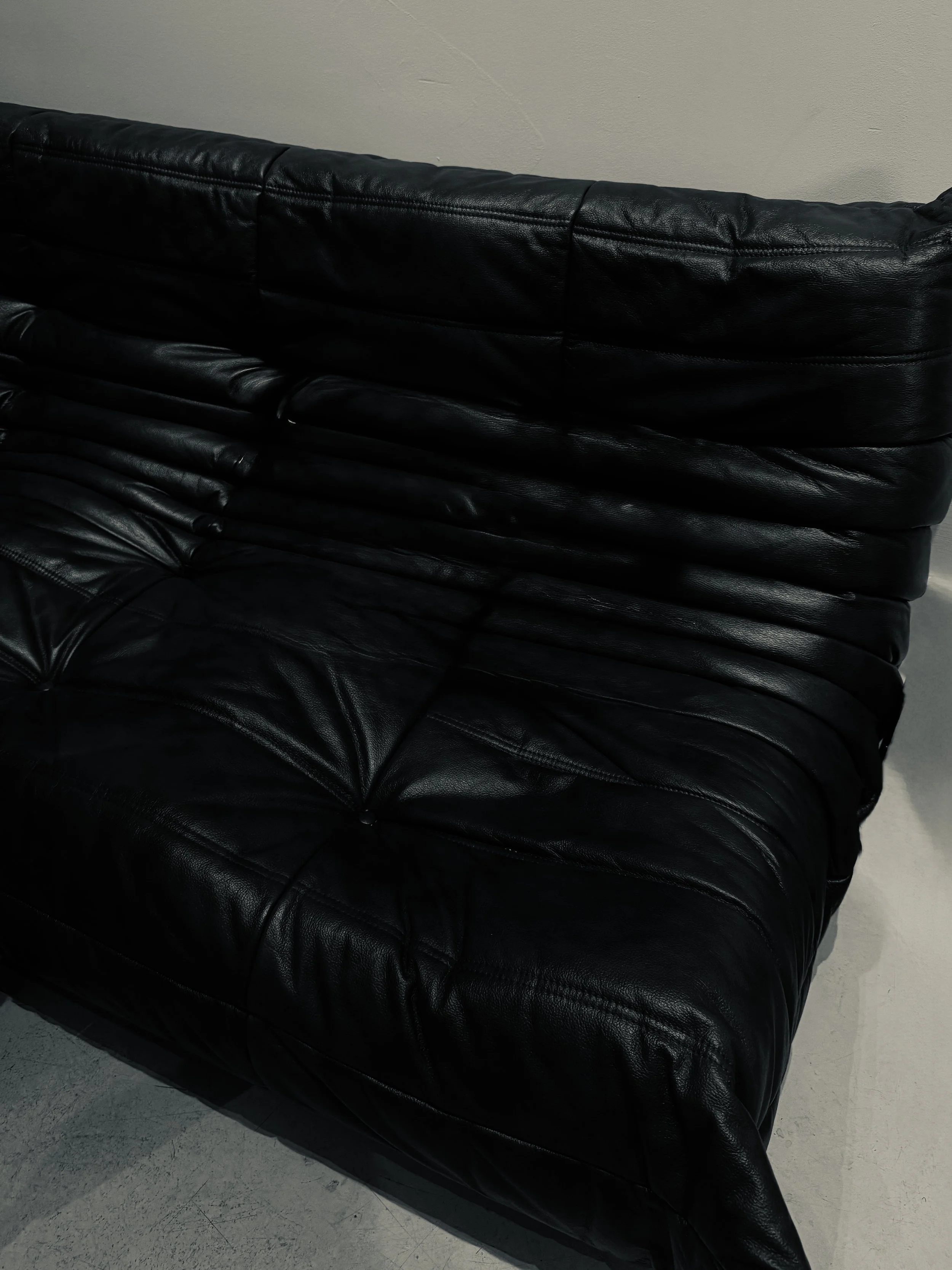 Close-up of black leather sofa texture, part of a creative studio interior