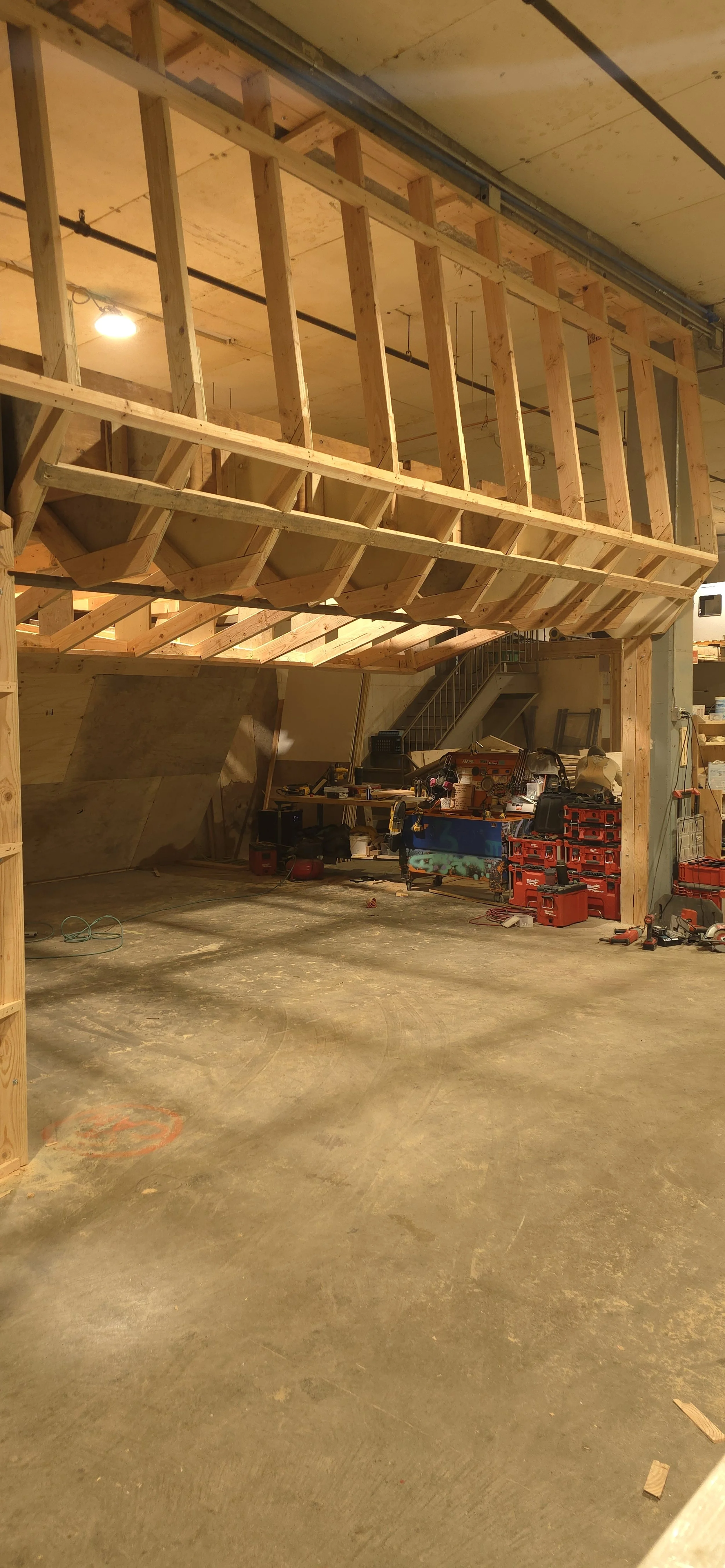 Construction site with wooden framing and tools in an unfinished building.