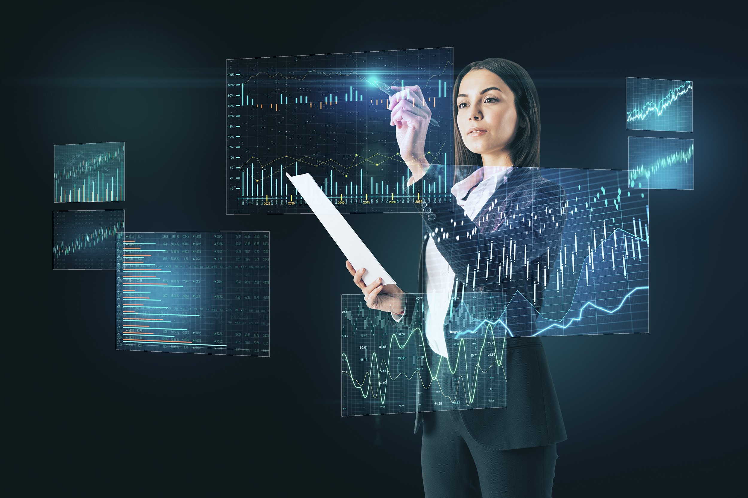 Businesswoman viewing various charts and graphs on holographic monitors floating in front of her.