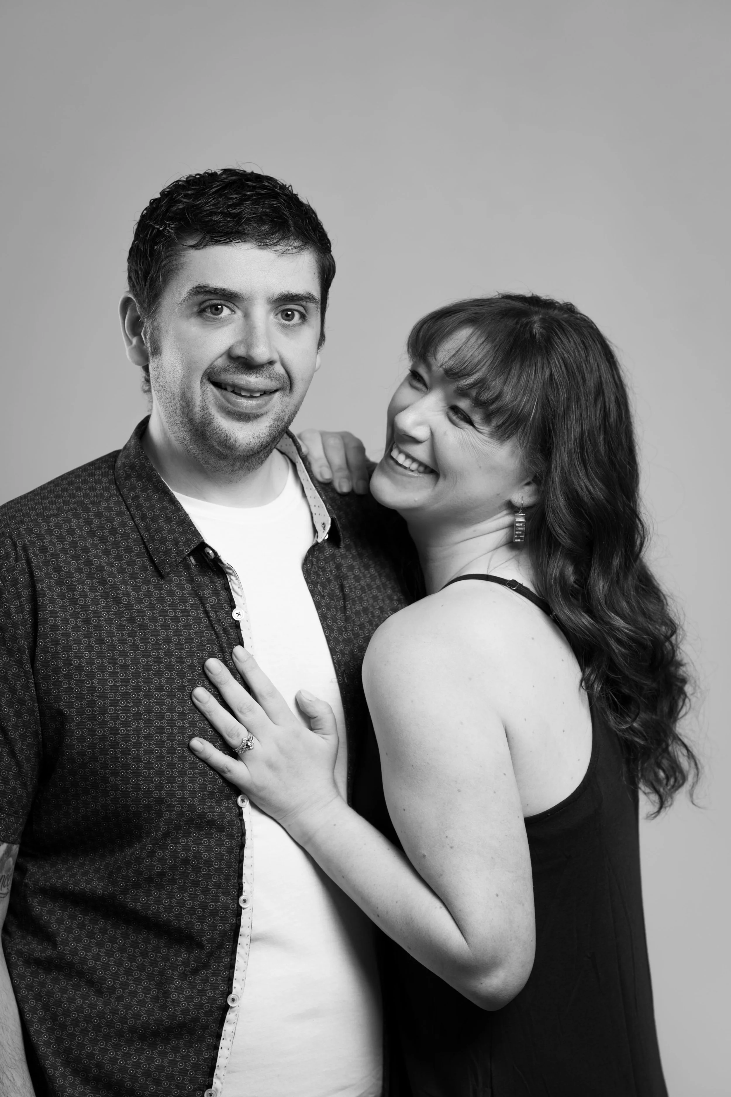 Happy couple shown in black and white, woman's hand on man's chest