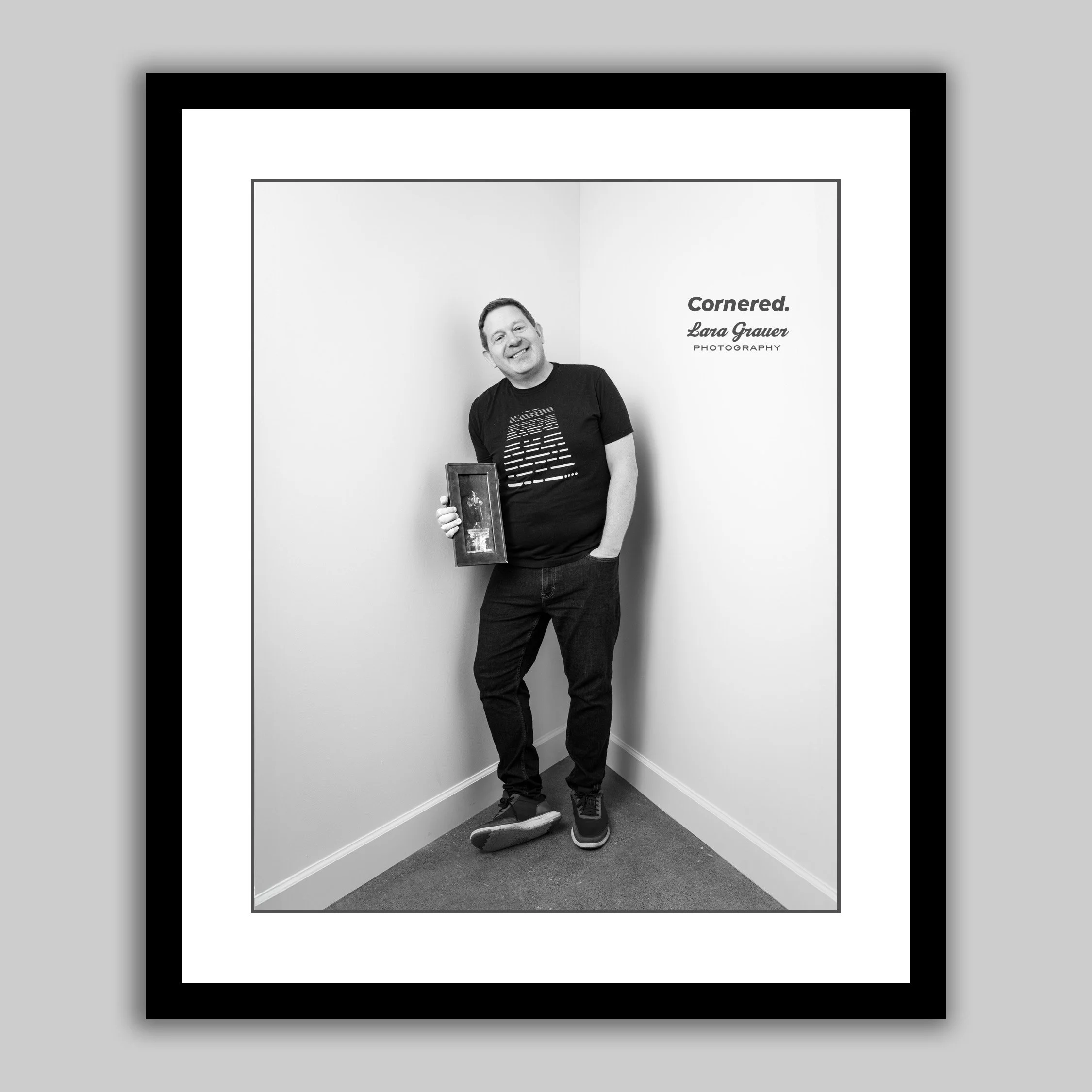 In this Cornered portrait, Mark holds a painting that his father made, depicting him in his role as the Auctioneer in Phantom of the Opera. It’s more than a memento; it’s a testament to his professional journey. Mark’s commitment to his acting career