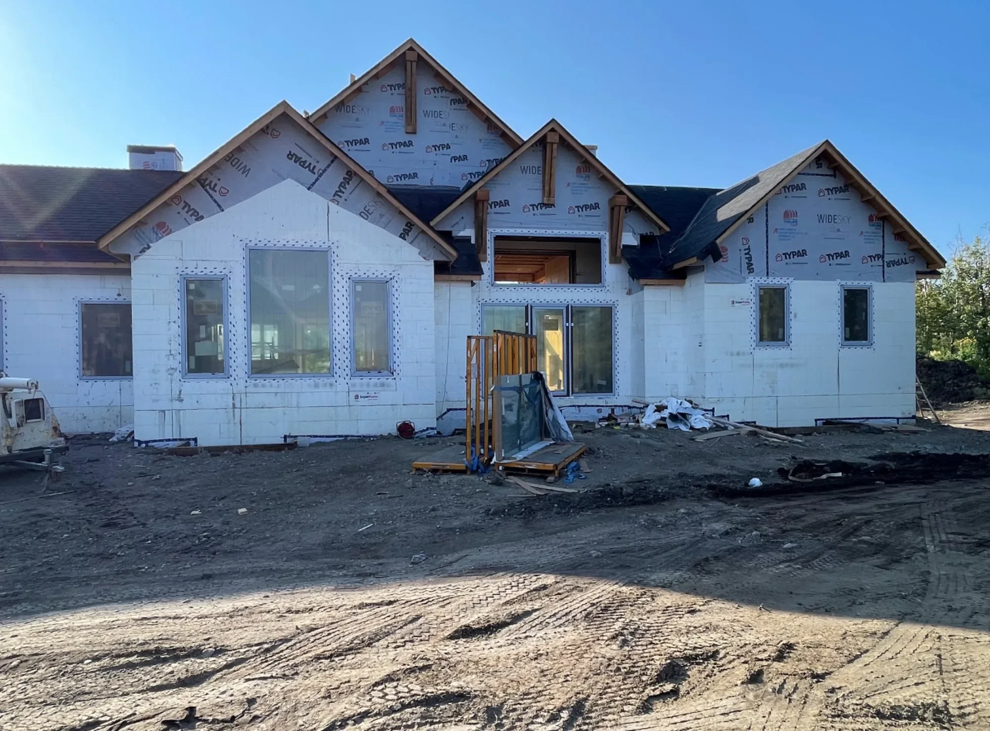Early-stage landscaping and site preparation for a new custom home in Calgary, including rough grading and exterior groundwork before final landscaping features are installed.
