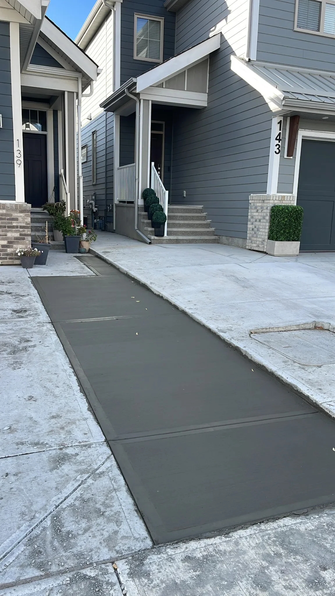 Clean, modern concrete walkway poured for a residential front entry, creating a durable and visually seamless transition from sidewalk to home. Finished with smooth edges and proper slope for drainage.