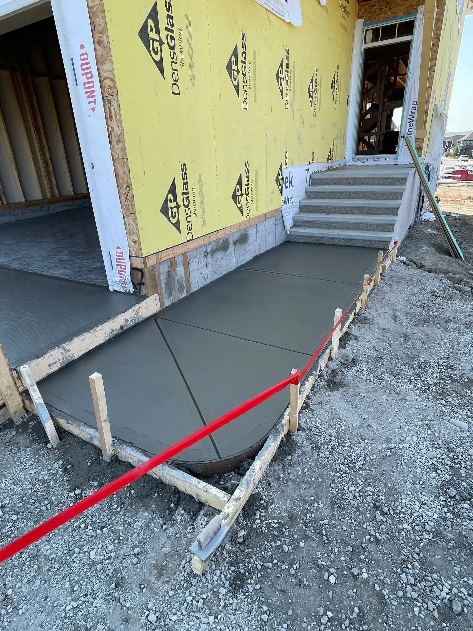 New construction concrete walkway and front entry pad poured with precise control joints and a smooth broom finish. Built to provide safe access and long-term durability, this entryway concrete is designed for Calgary’s climate and modern home constr
