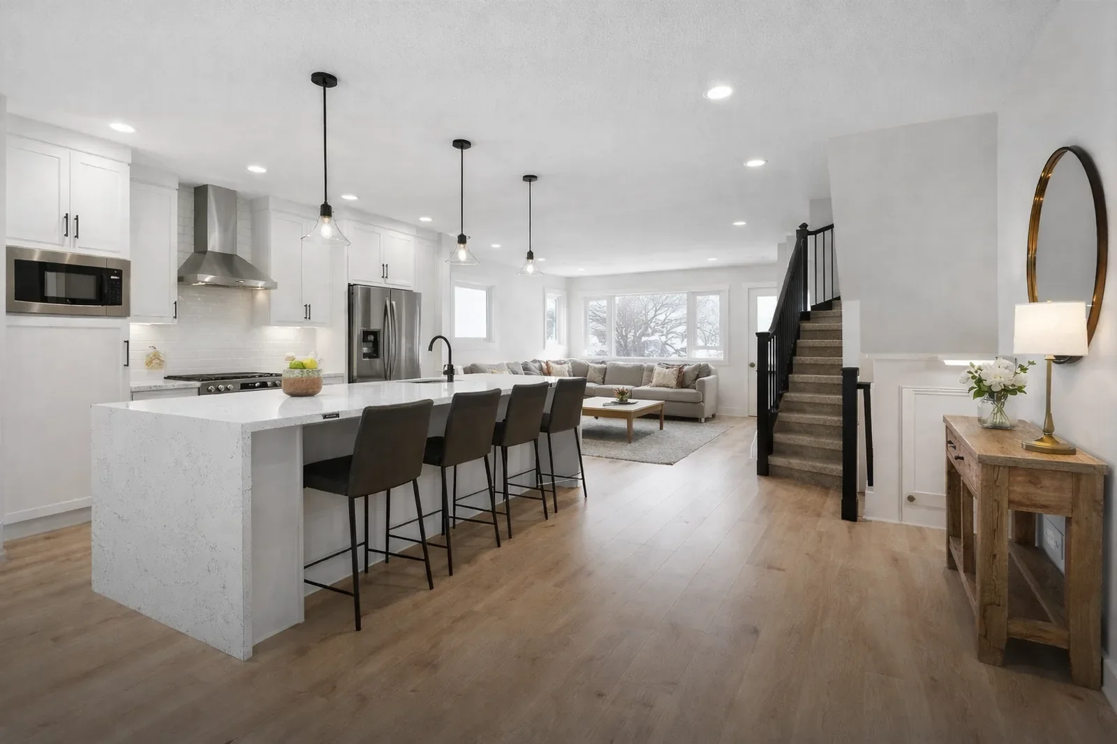 Full home remodel featuring an open-concept kitchen and living space with quartz island, modern finishes, and natural light in a Calgary home.