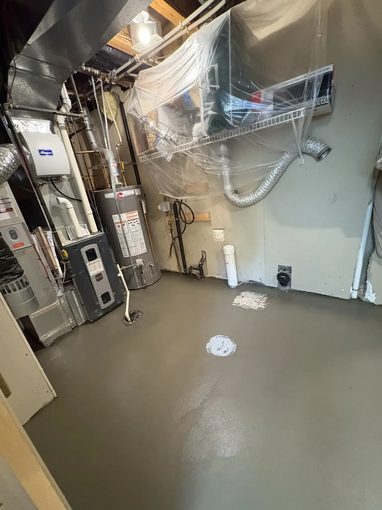 Concrete basement floor poured and leveled to create a clean, durable surface around mechanical systems, providing a solid foundation for future finishing or utility use.