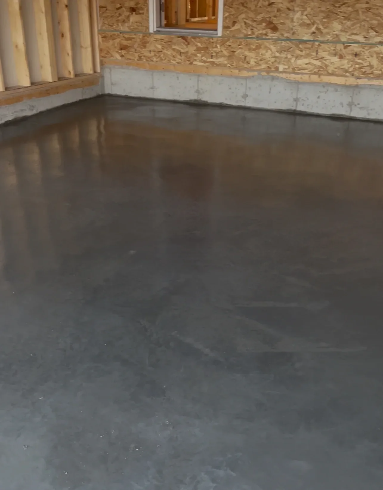 Smooth interior concrete slab poured for a basement floor, providing a strong, level foundation ready for framing and finishing. This clean concrete pour ensures long-term durability and structural integrity for Calgary residential basements.