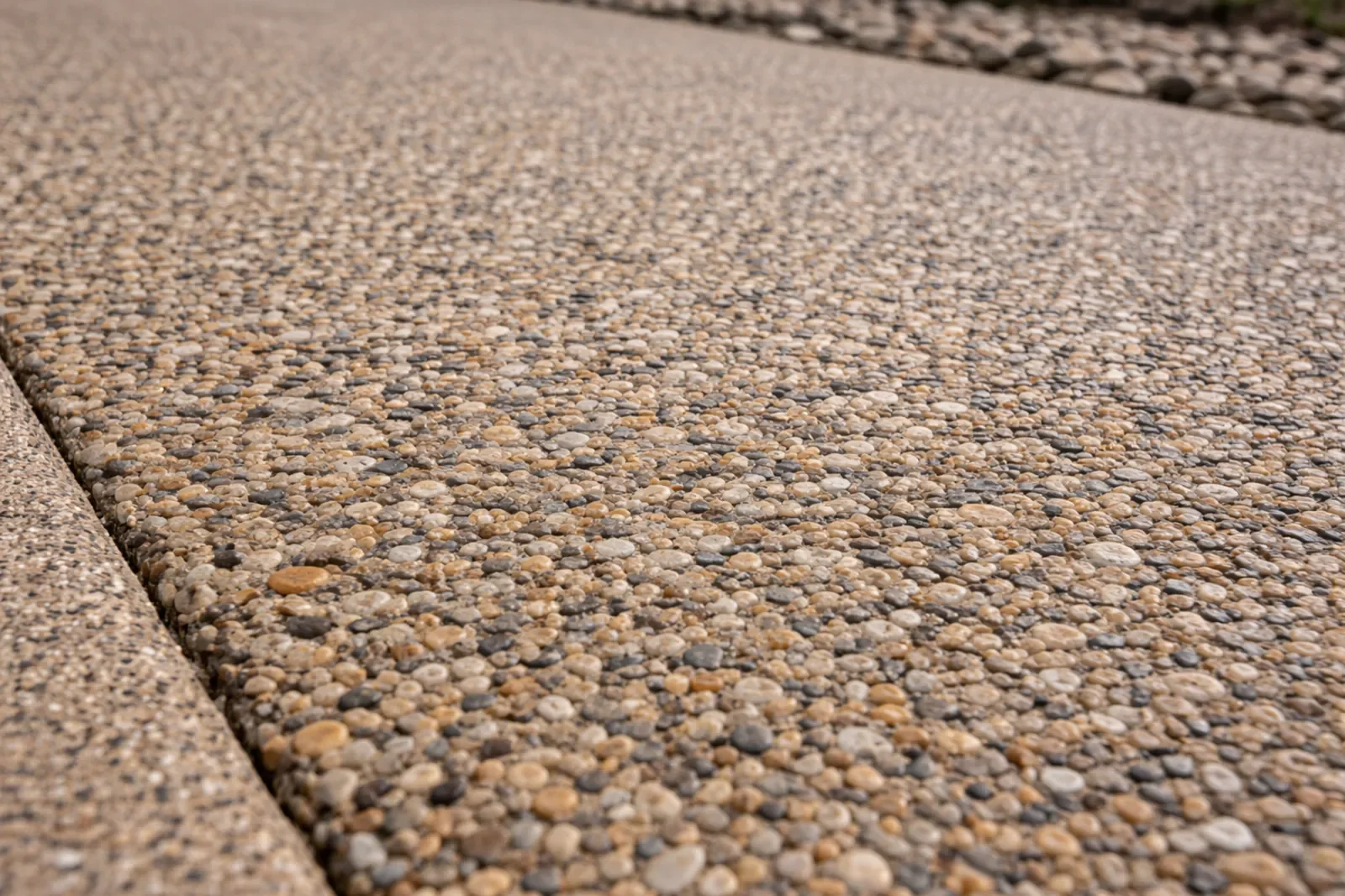 Exposed aggregate concrete driveway with natural stone texture and durable finish